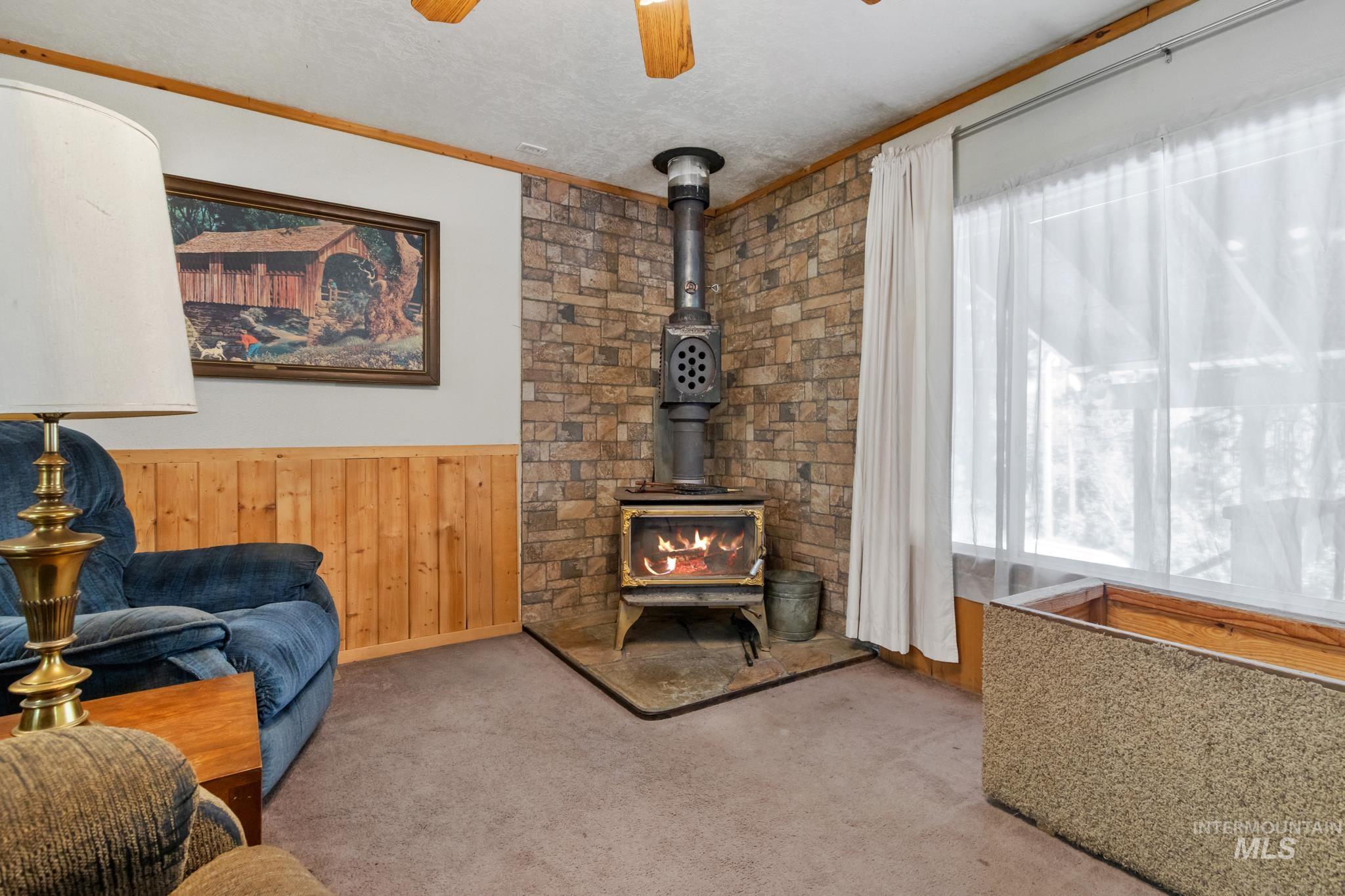 Corner wood-burning stove with a stone surround, set on a dark hearth