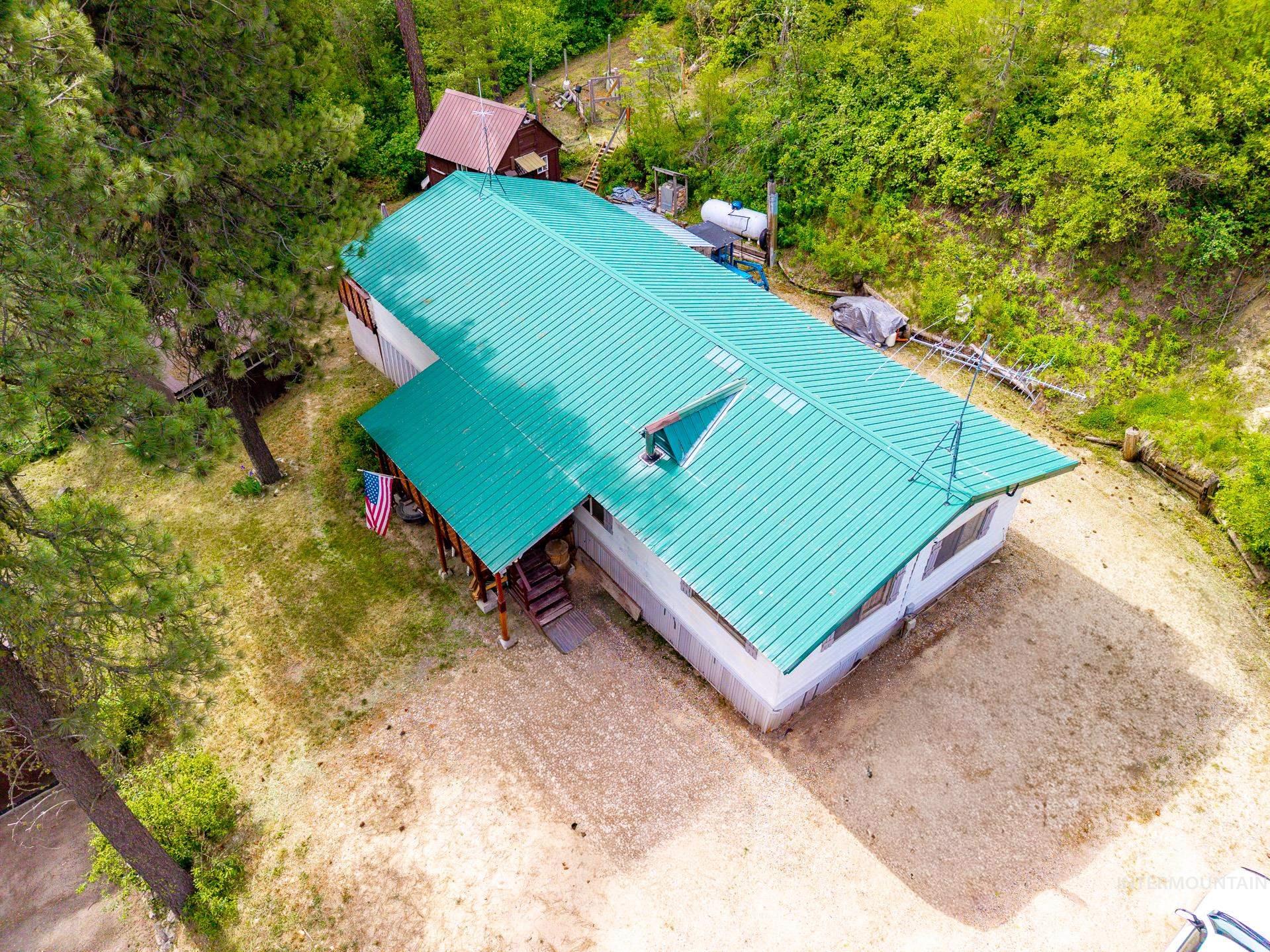 Ranch-style residence featuring a vibrant green metal roof and a covered porch entry