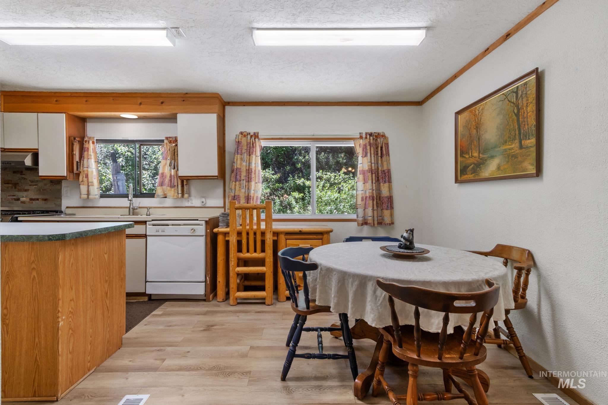 Kitchen and dining area featuring wood-finish flooring