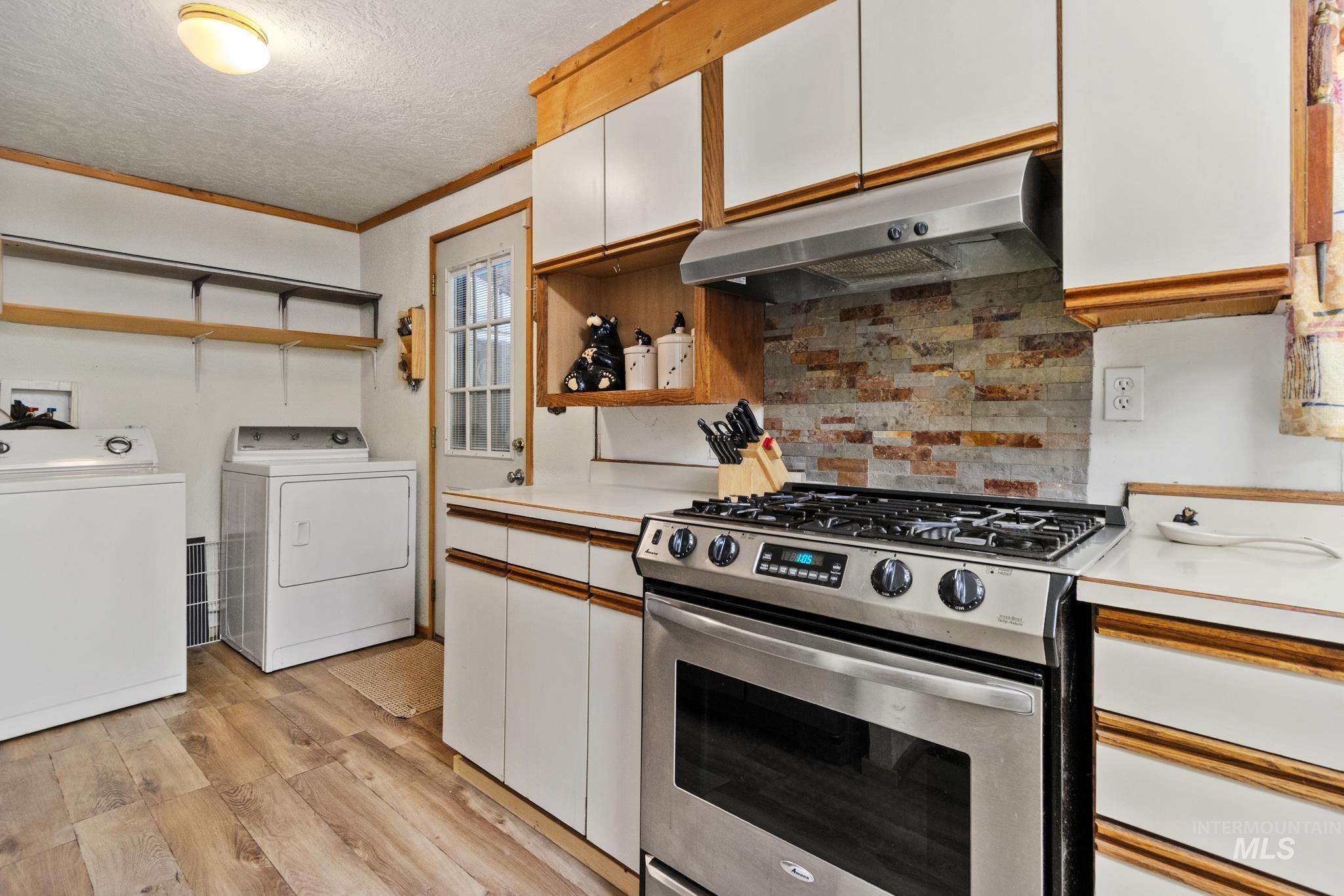 Kitchen with wood-finish flooring and white cabinetry