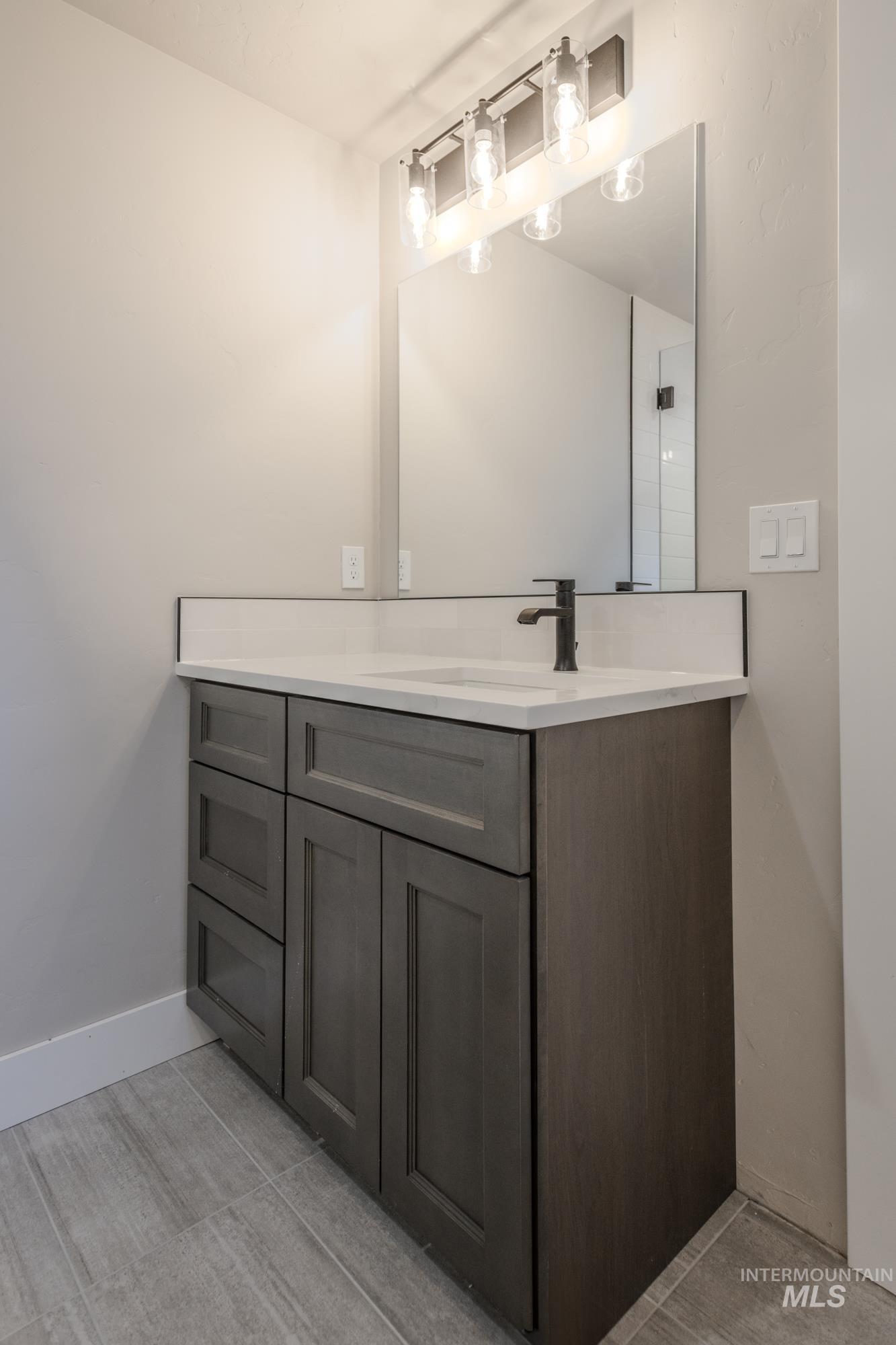 Bathroom with vanity and baseboards, tiled shower, off of 2nd en-suite master on main level.