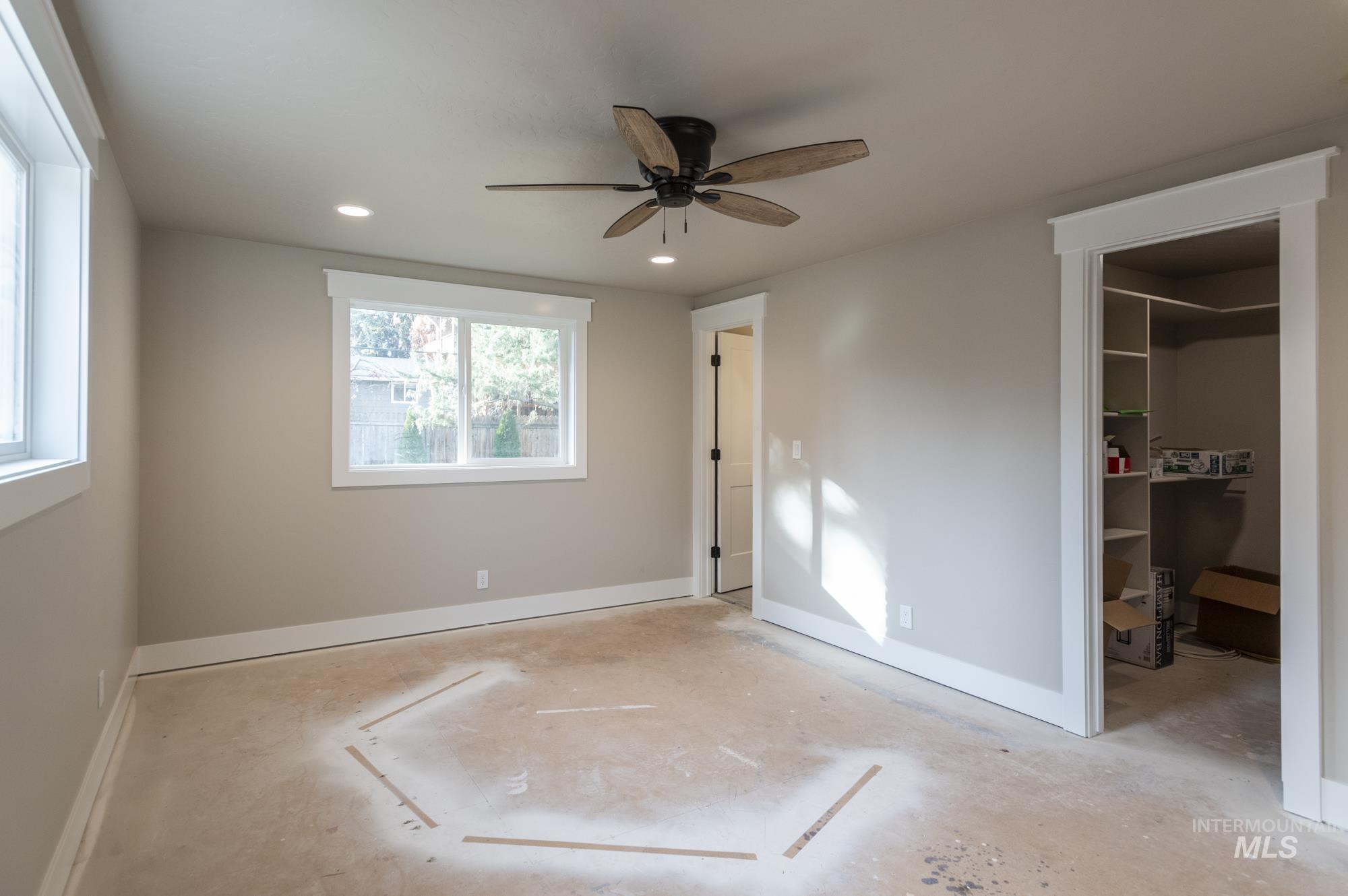 Unfurnished bedroom with ceiling fan, recessed lighting, a walk in closet, and en-suite bath.