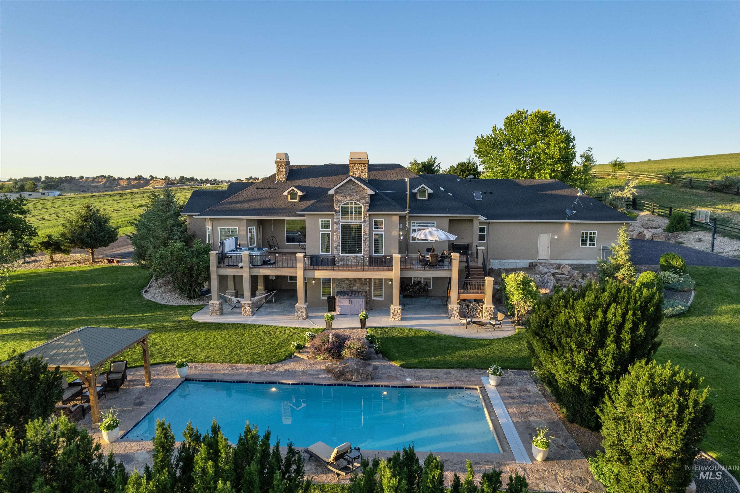 Back of property featuring stairway, a wooden deck, a chimney, a patio, and a lawn