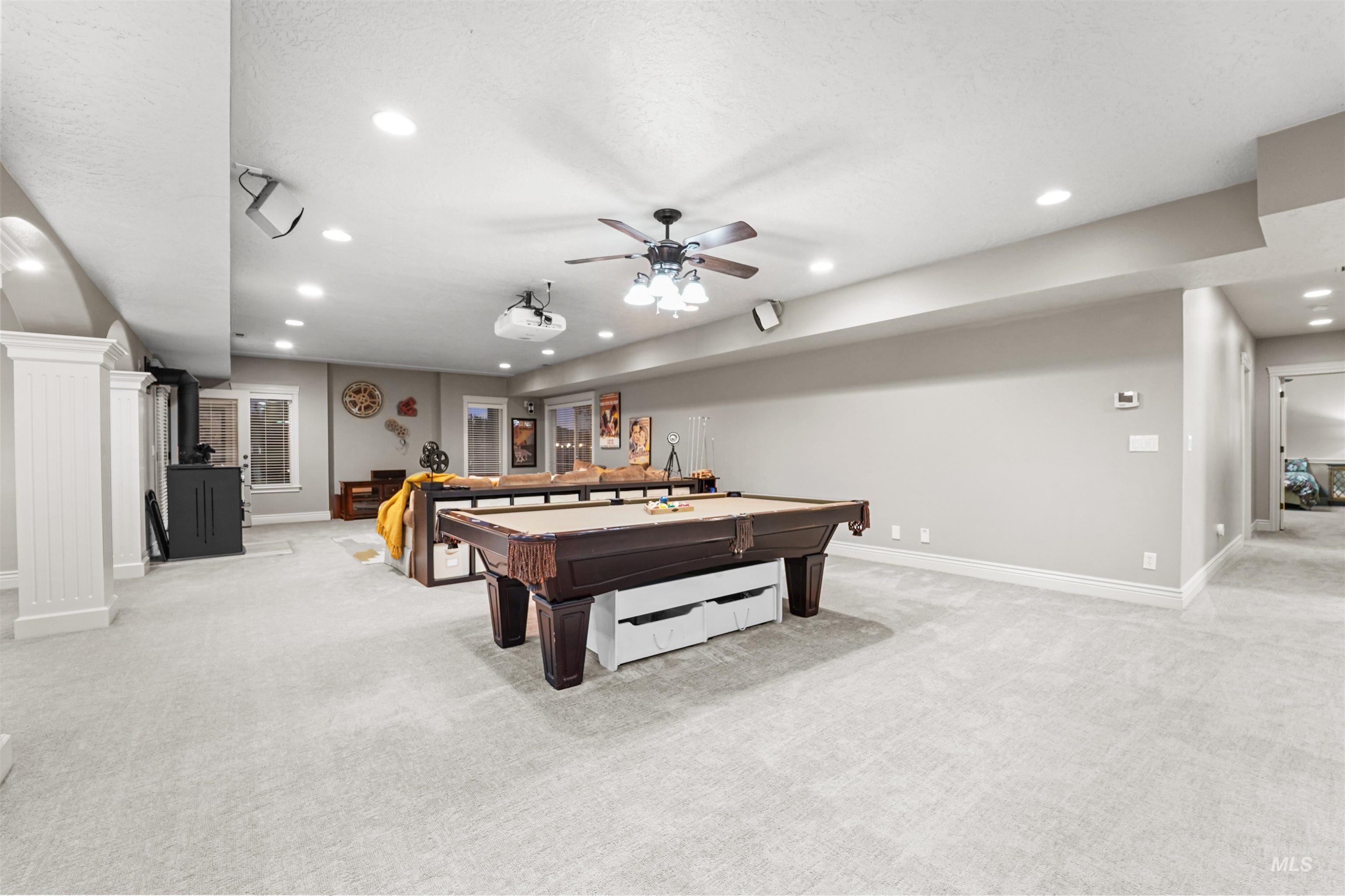 Rec room with light colored carpet, recessed lighting, pool table, a ceiling fan, and a wood stove