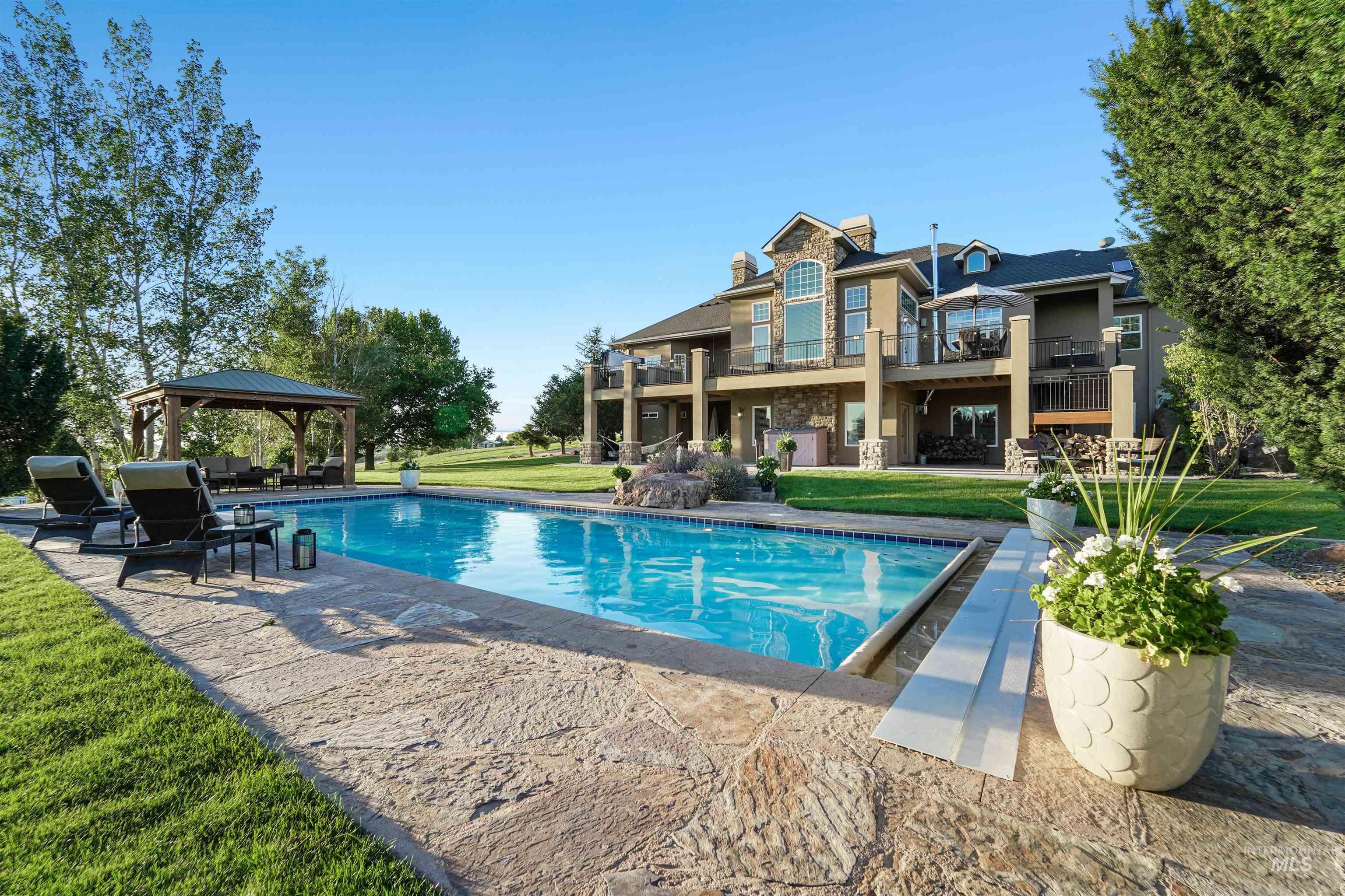 Swimming pool featuring a patio area, a gazebo, and a lawn