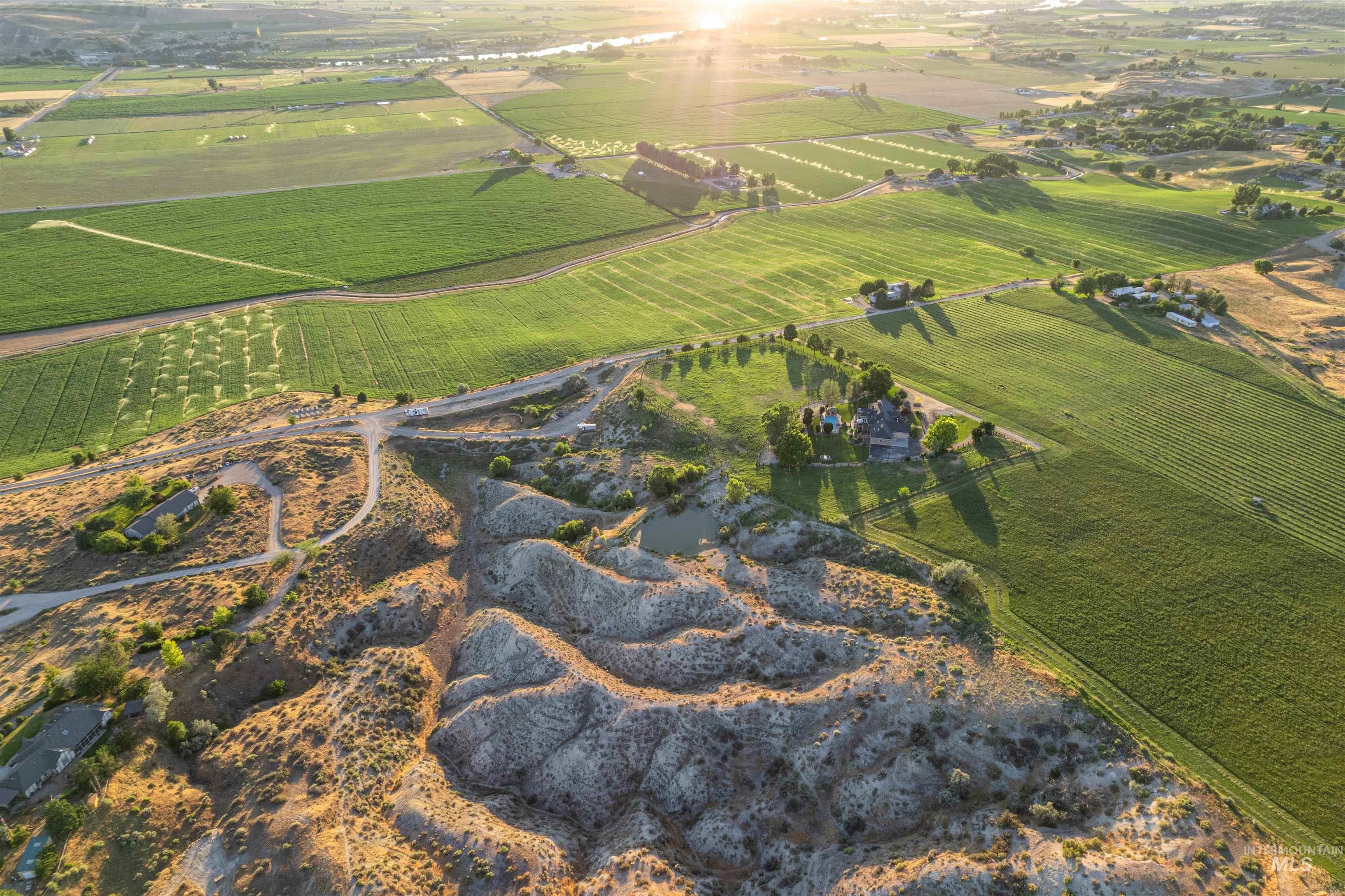 Aerial view of property and surrounding area with rural landscape and rows of crops