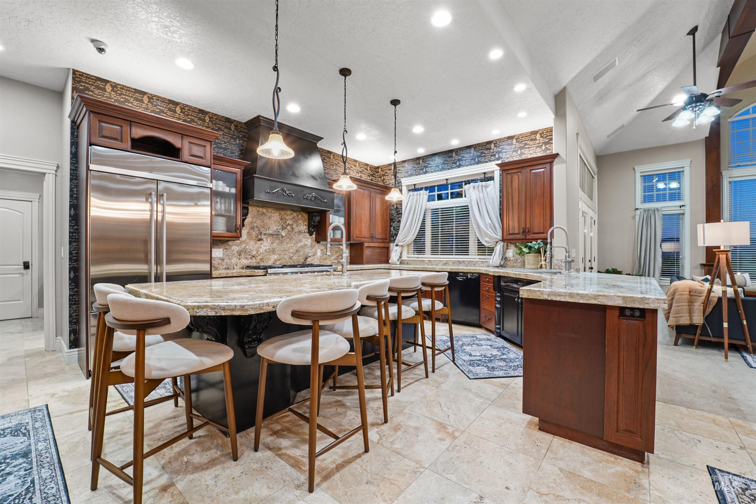 Kitchen with built in fridge, a peninsula, extractor fan, black dishwasher, and backsplash