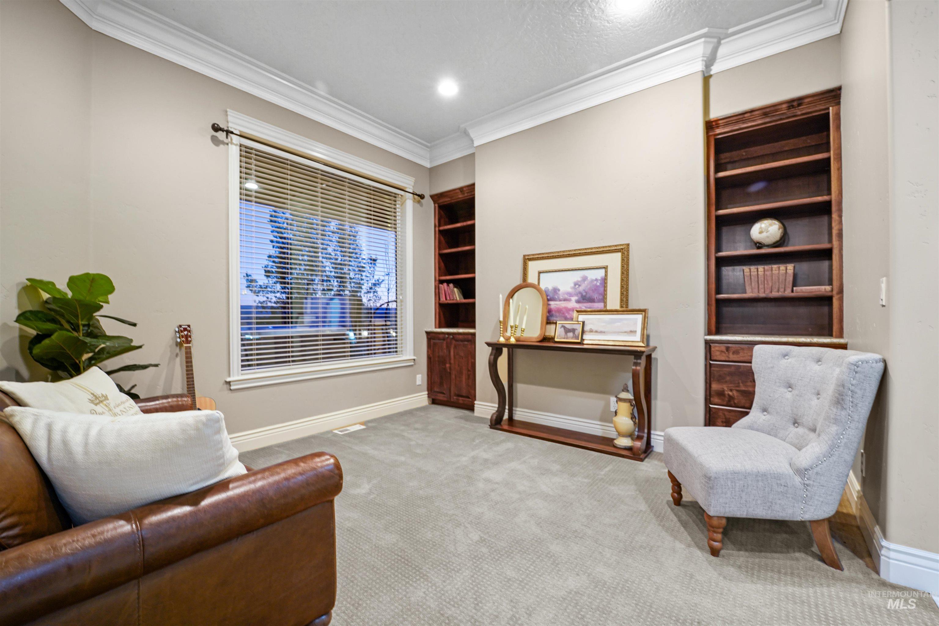 Sitting room with crown molding, carpet floors, and built in features