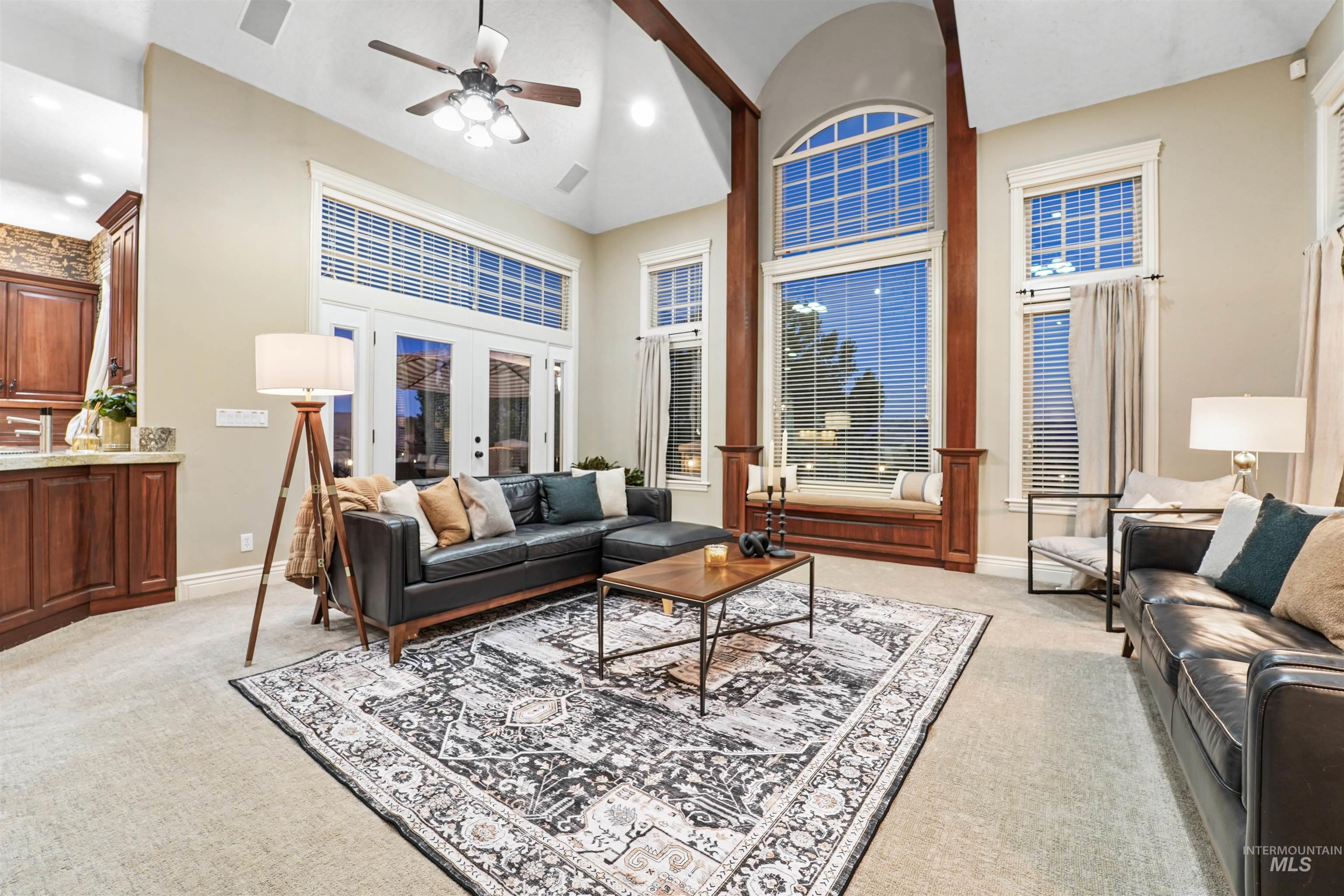 Living area with light carpet, french doors, a ceiling fan, high vaulted ceiling, and recessed lighting