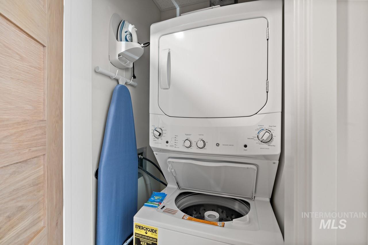 Laundry room with stacked washing machine and dryer