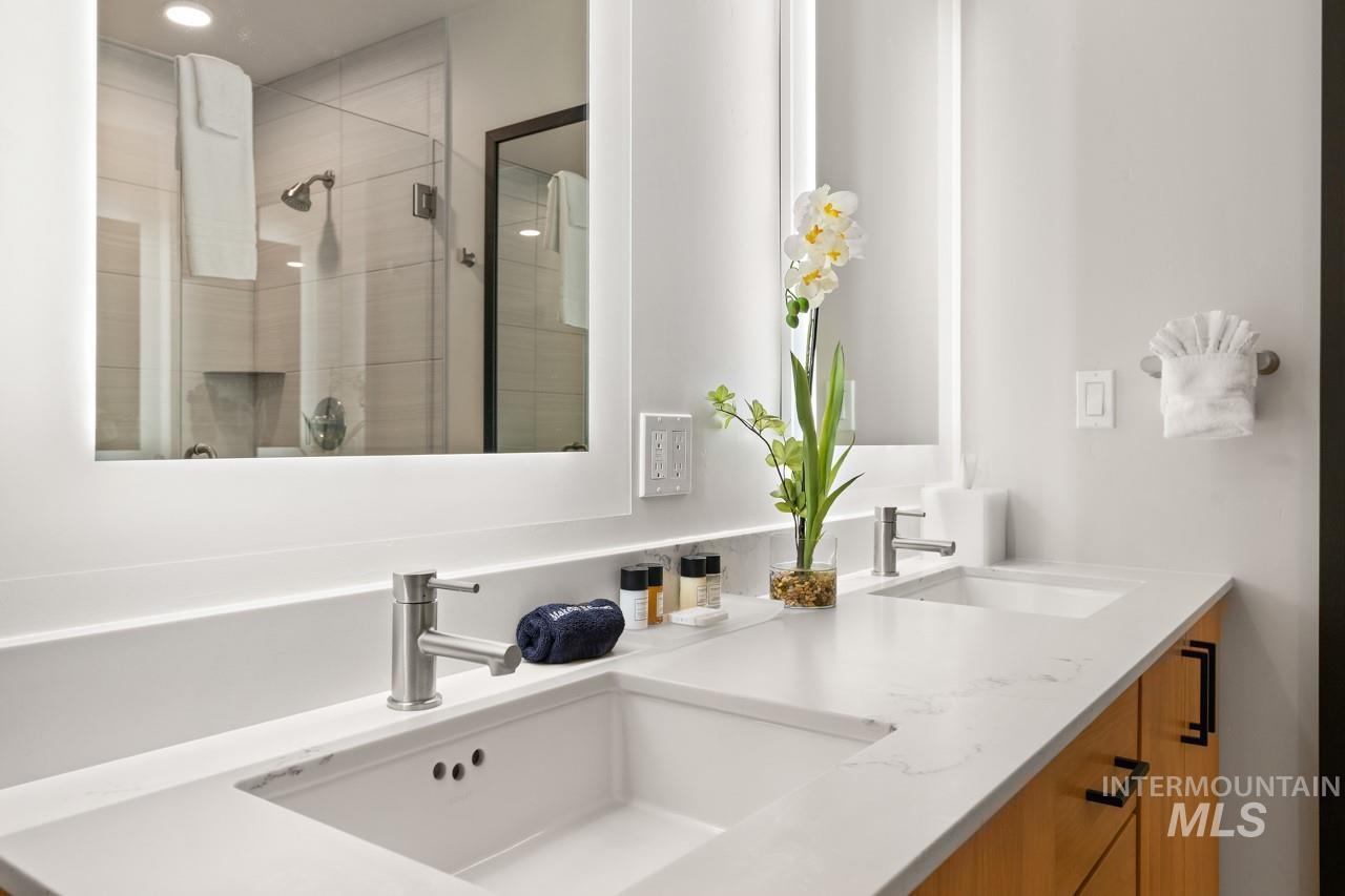 Bathroom featuring double vanity, a stall shower, and recessed lighting