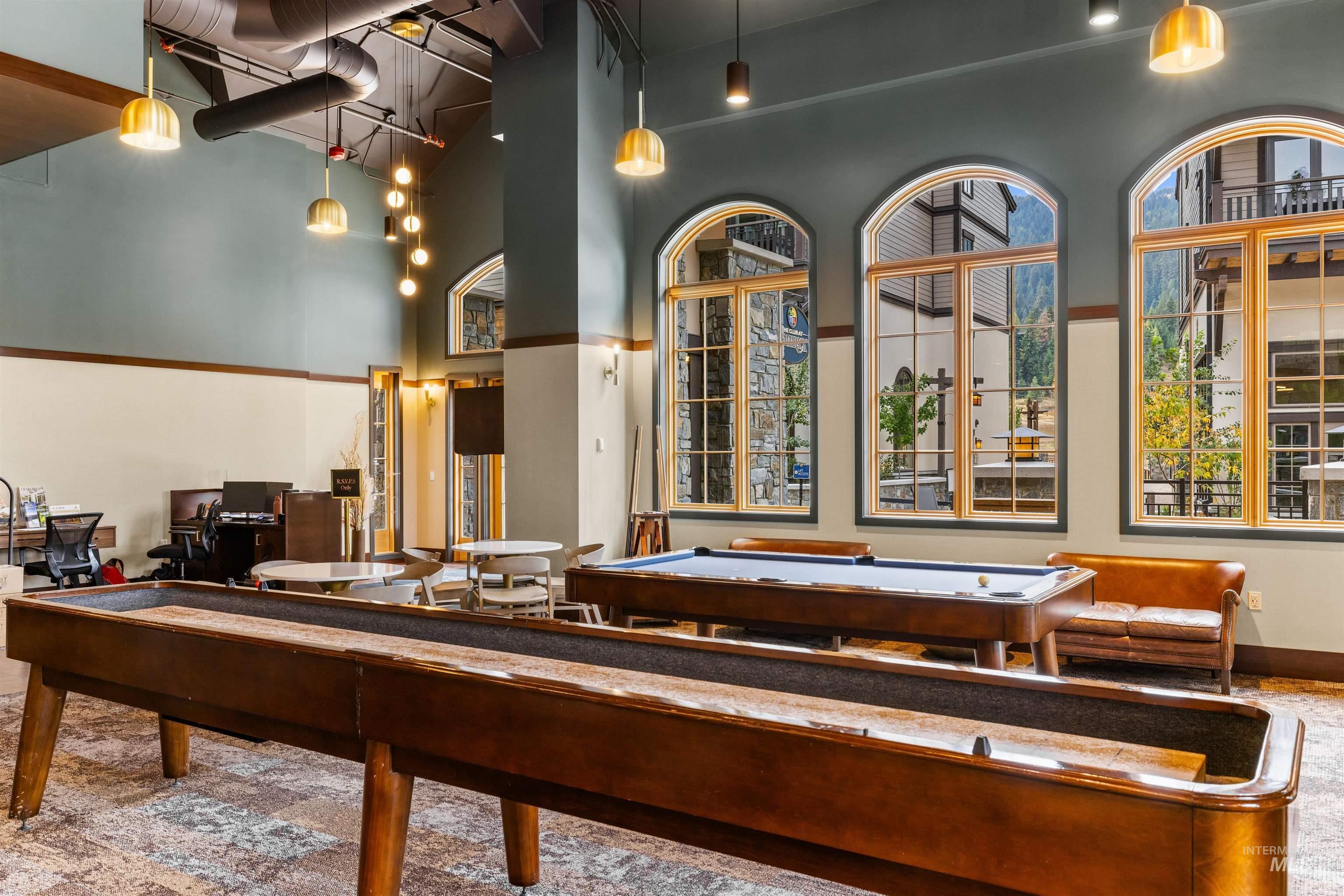 Game room with a towering ceiling, plenty of natural light, and billiards