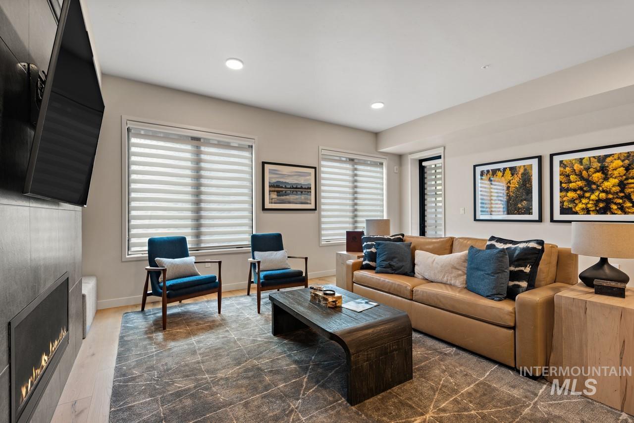 Living room with a warm lit fireplace and recessed lighting