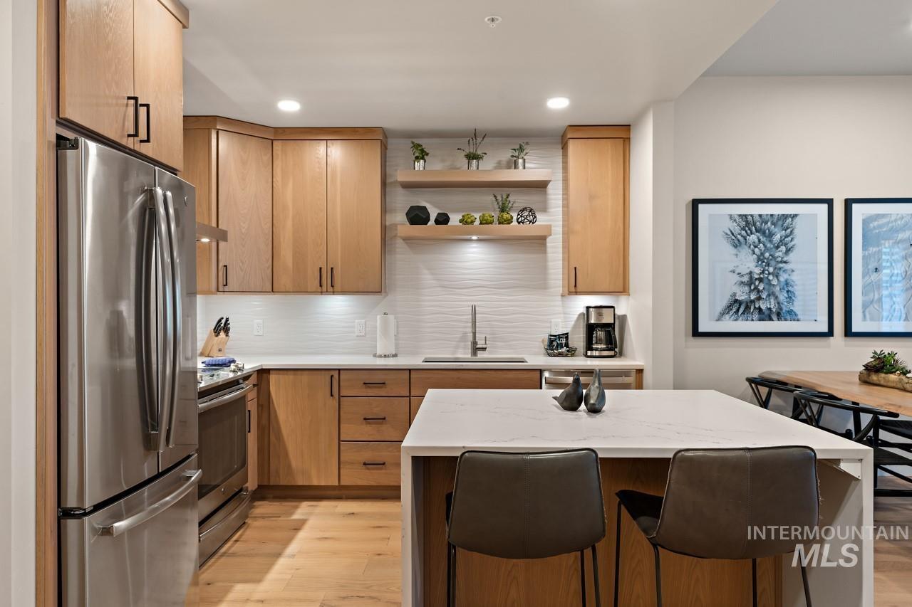 Kitchen featuring stainless steel appliances, open shelves, light wood-style flooring, backsplash, and recessed lighting