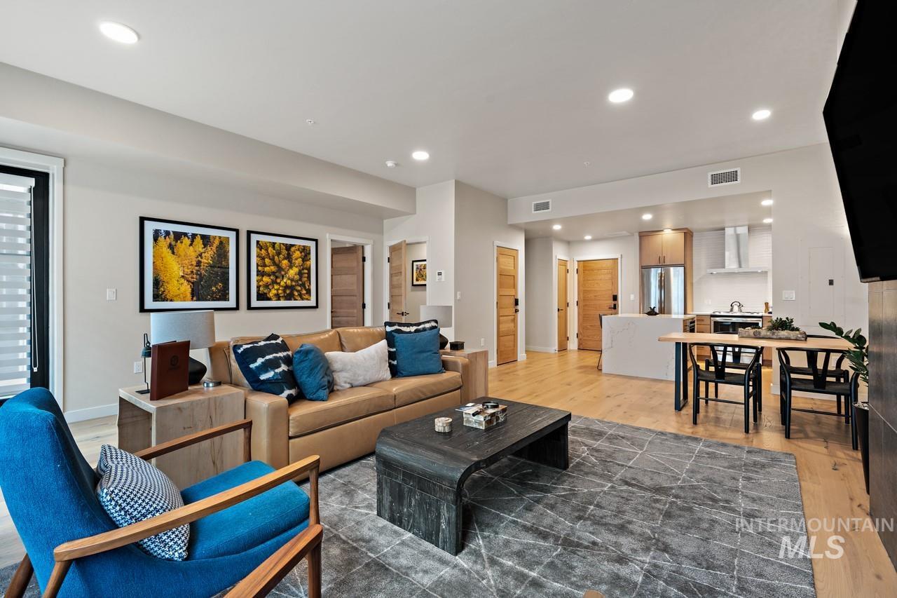 Living room with light wood finished floors and recessed lighting