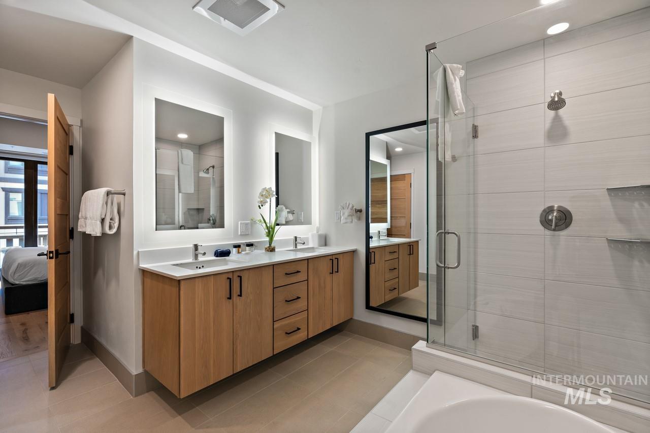 Ensuite bathroom with double vanity, a stall shower, tile patterned flooring, a bath, and recessed lighting