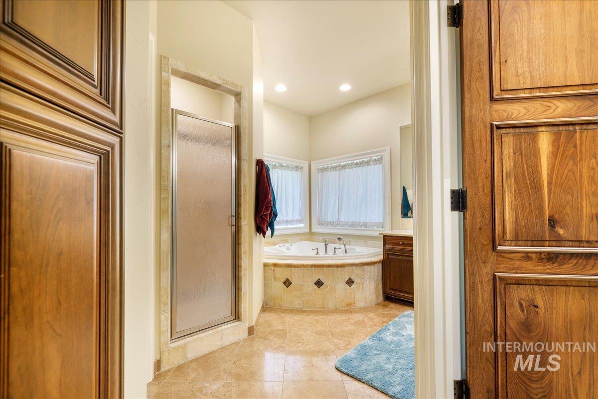 Full bathroom with a stall shower, a bath, tile patterned flooring, vanity, and recessed lighting