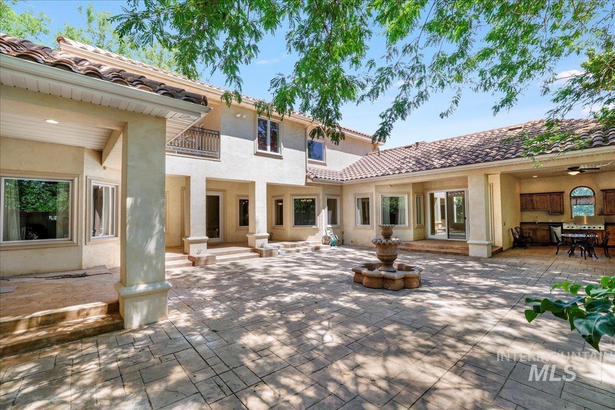 Back of house featuring a patio, stucco siding, and a tile roof