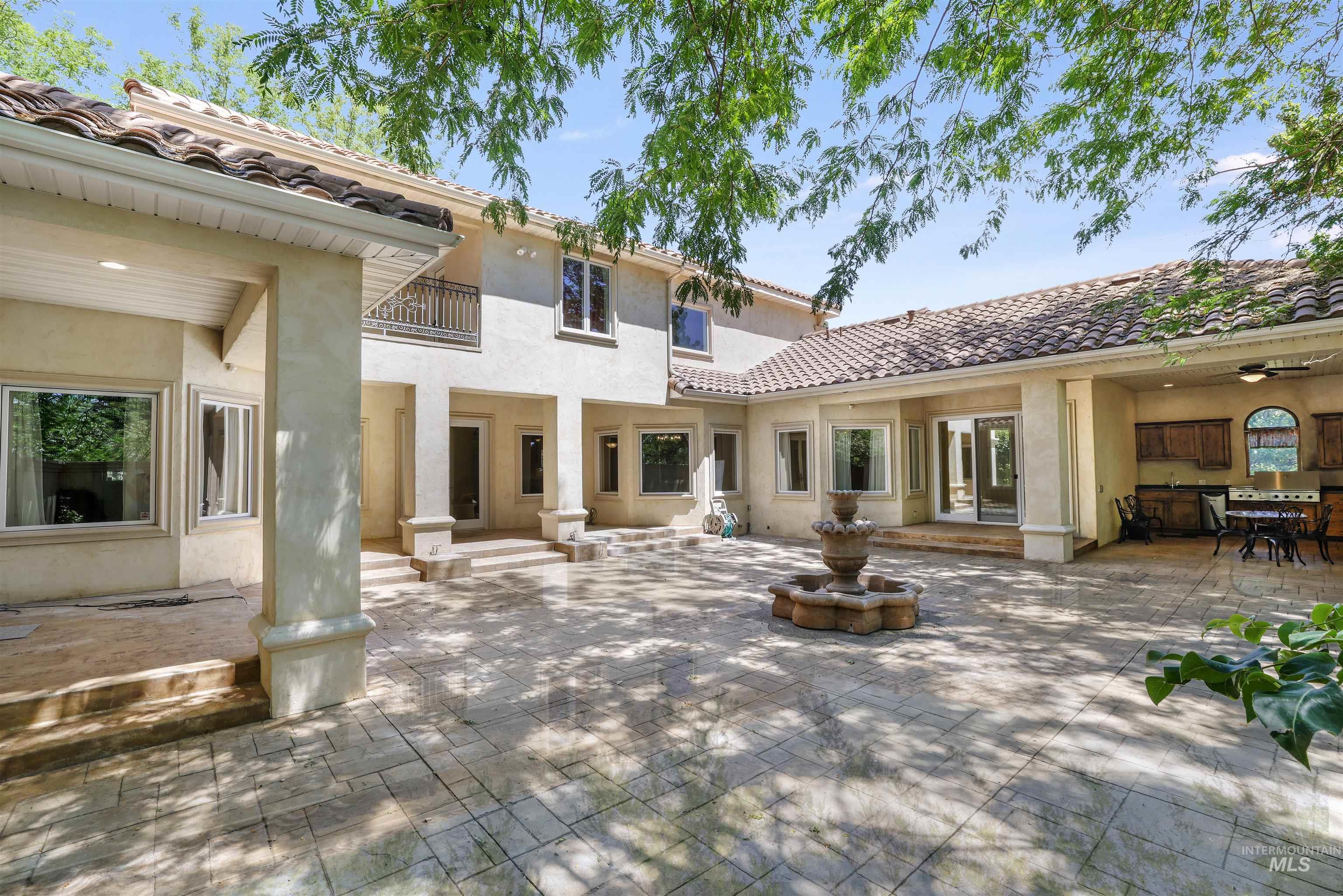 Back of house featuring a patio, stucco siding, and a tile roof
