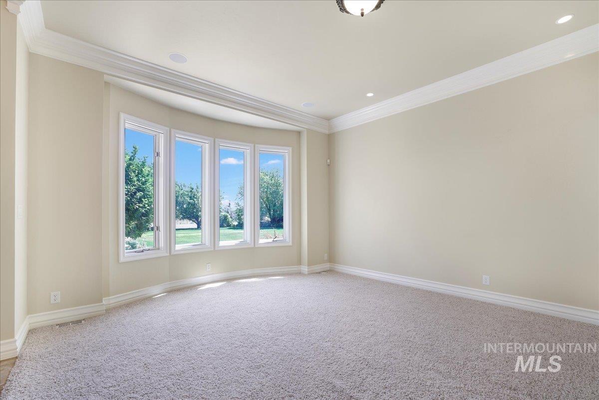 Spare room featuring ornamental molding, light carpet, and recessed lighting