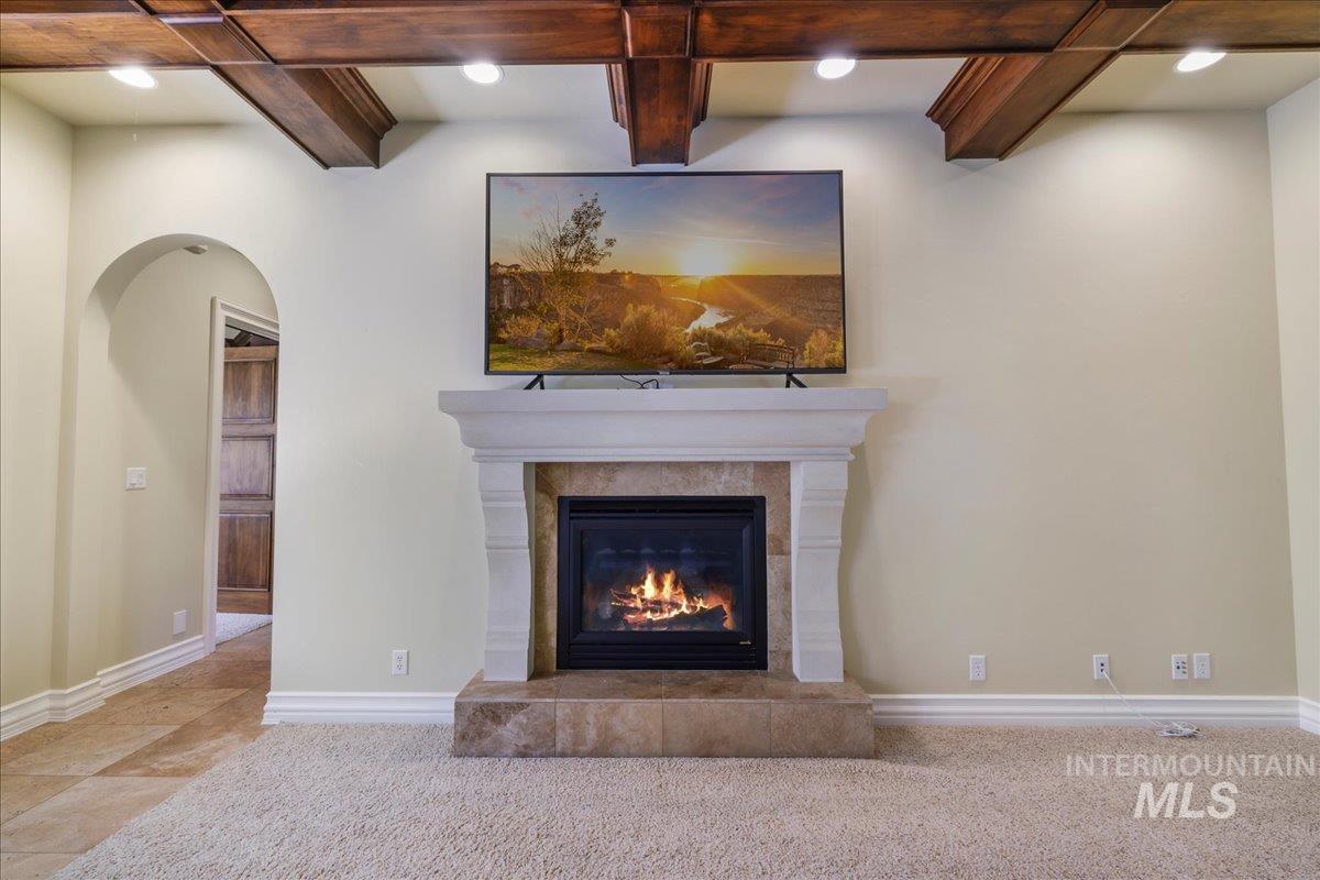 Detailed view of a tile fireplace, recessed lighting, and carpet flooring
