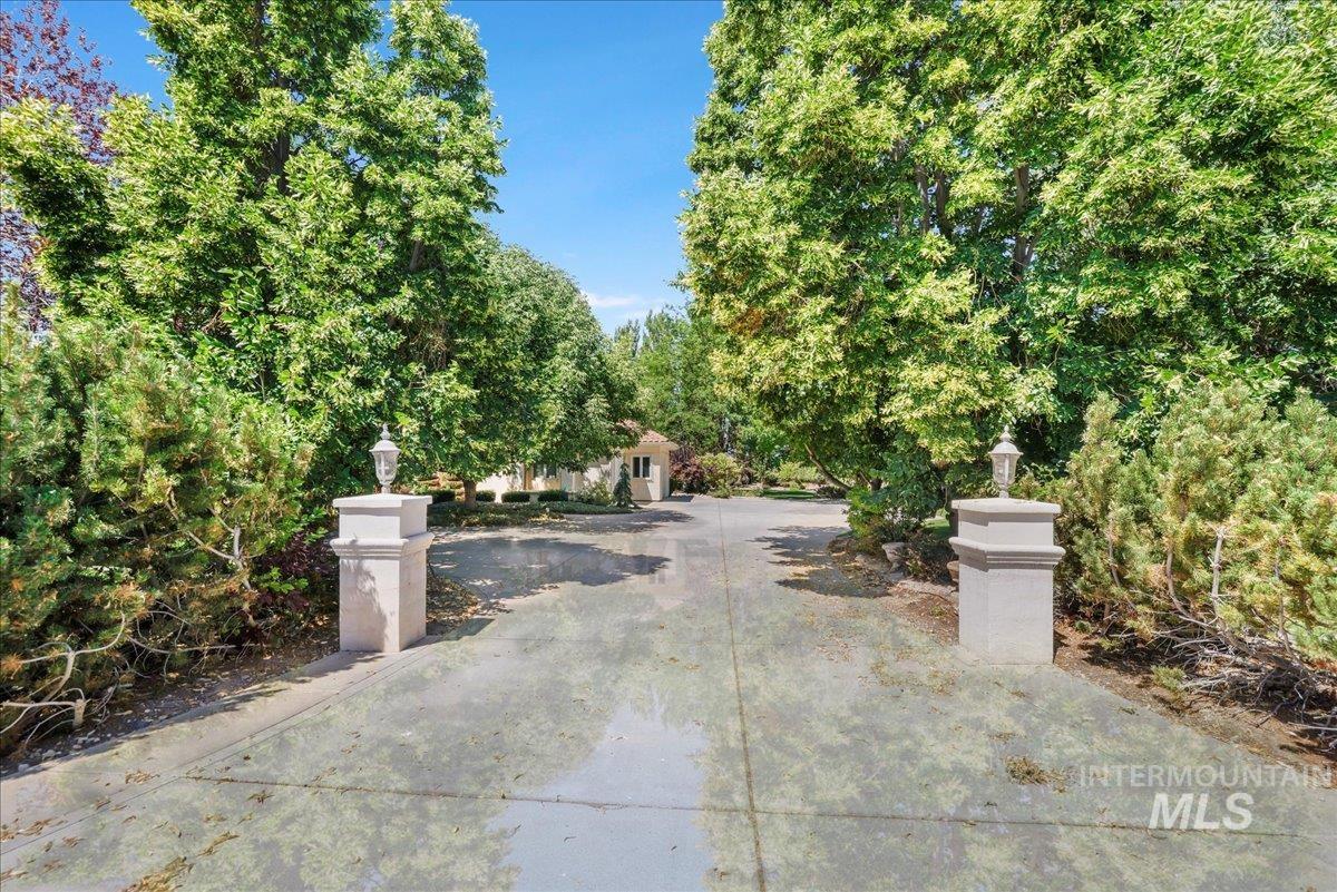 View of concrete driveway featuring street lights