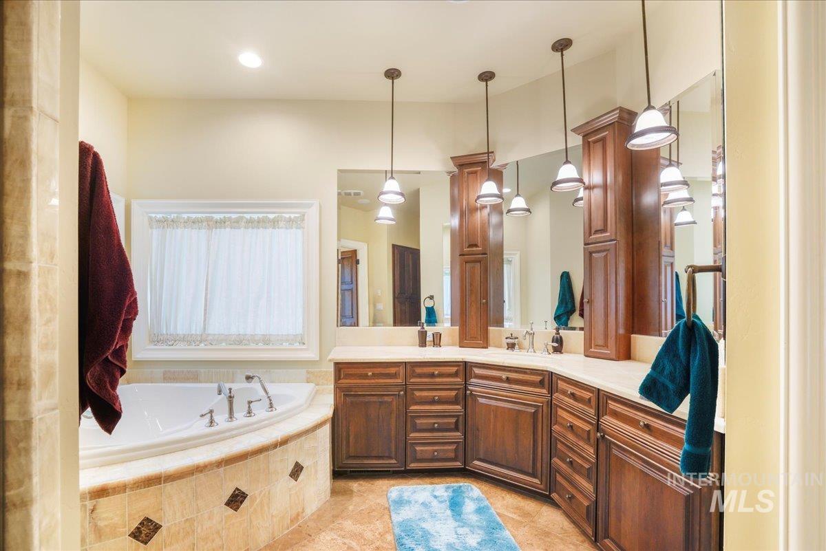 Bathroom with double vanity, a bath, and tile patterned floors