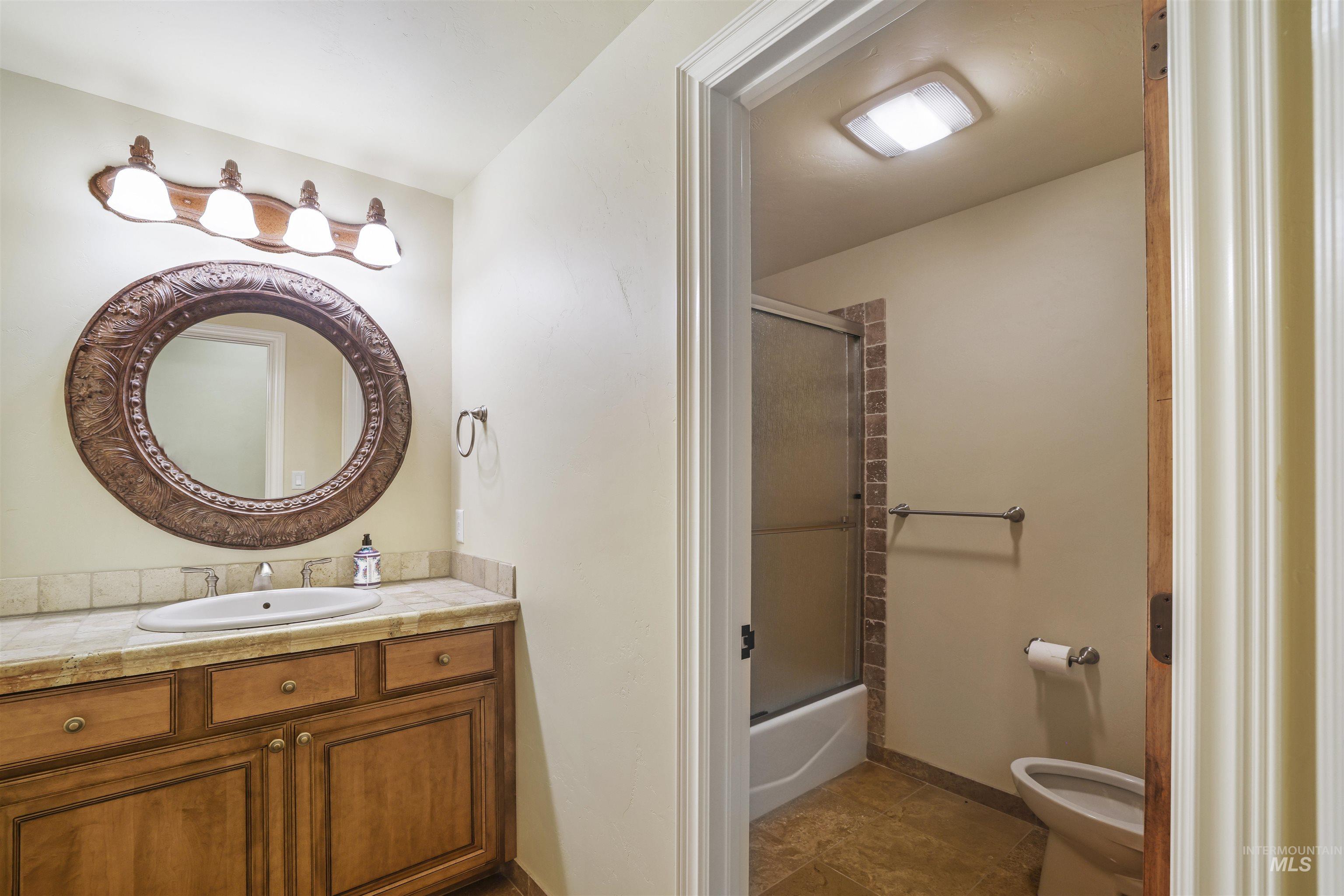 Full bath with vanity and bath / shower combo with glass door