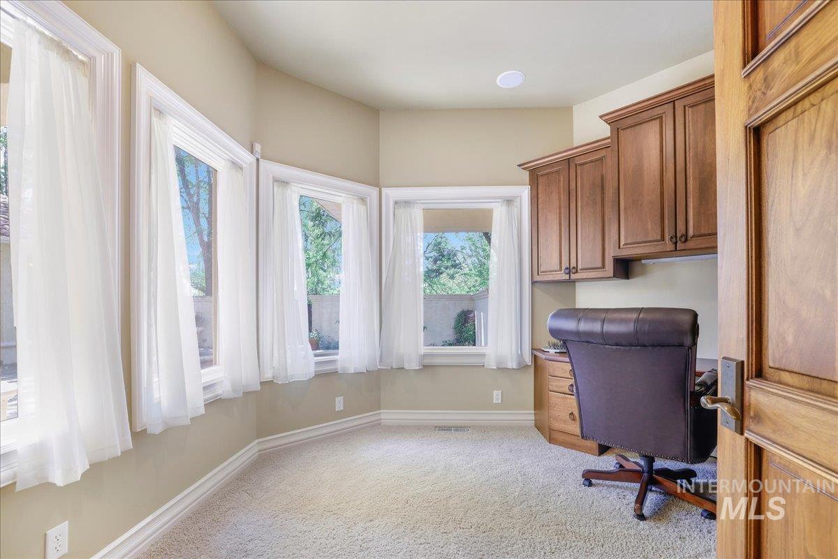 Unfurnished office with light carpet and built in study area