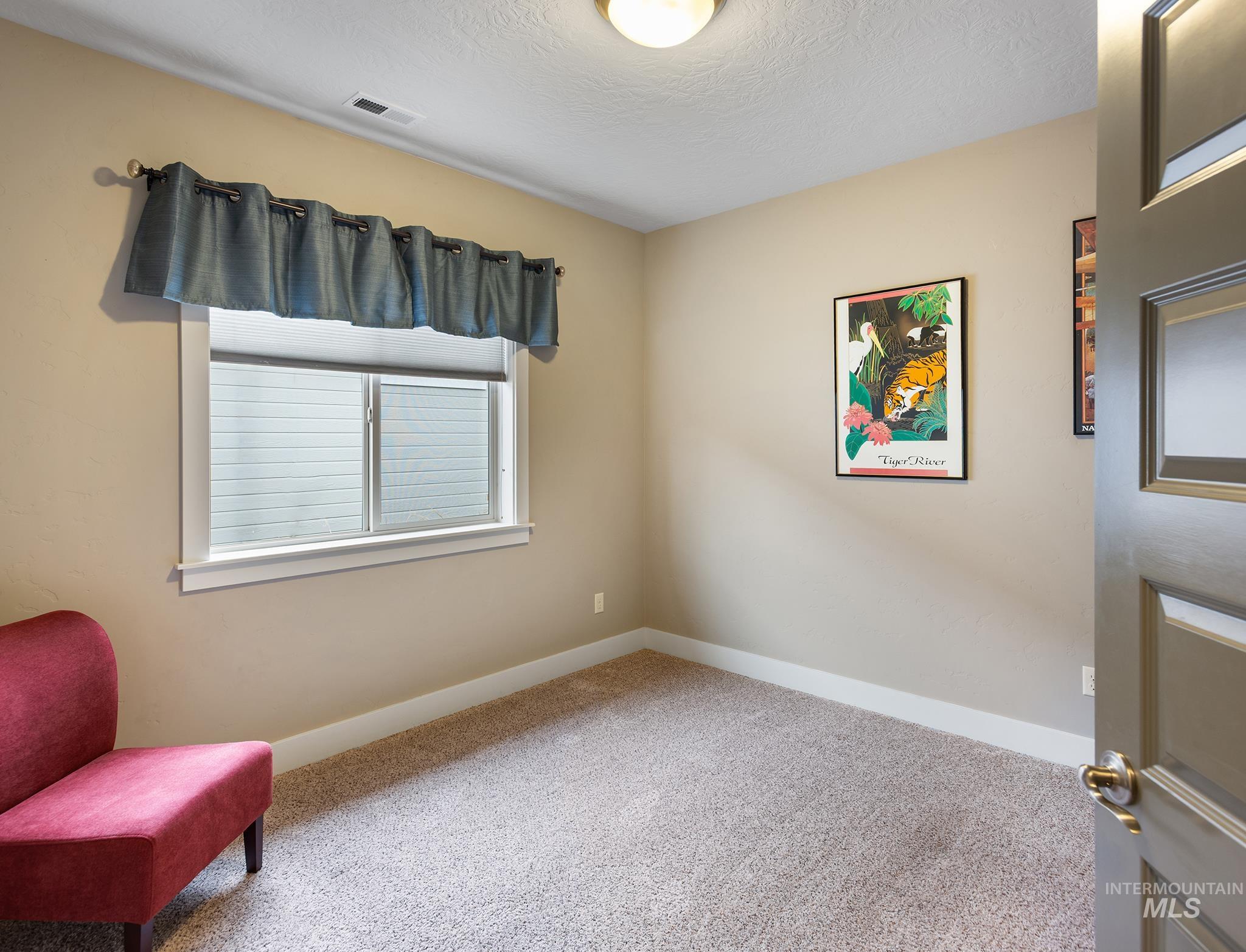 Living area featuring carpet flooring and a textured ceiling