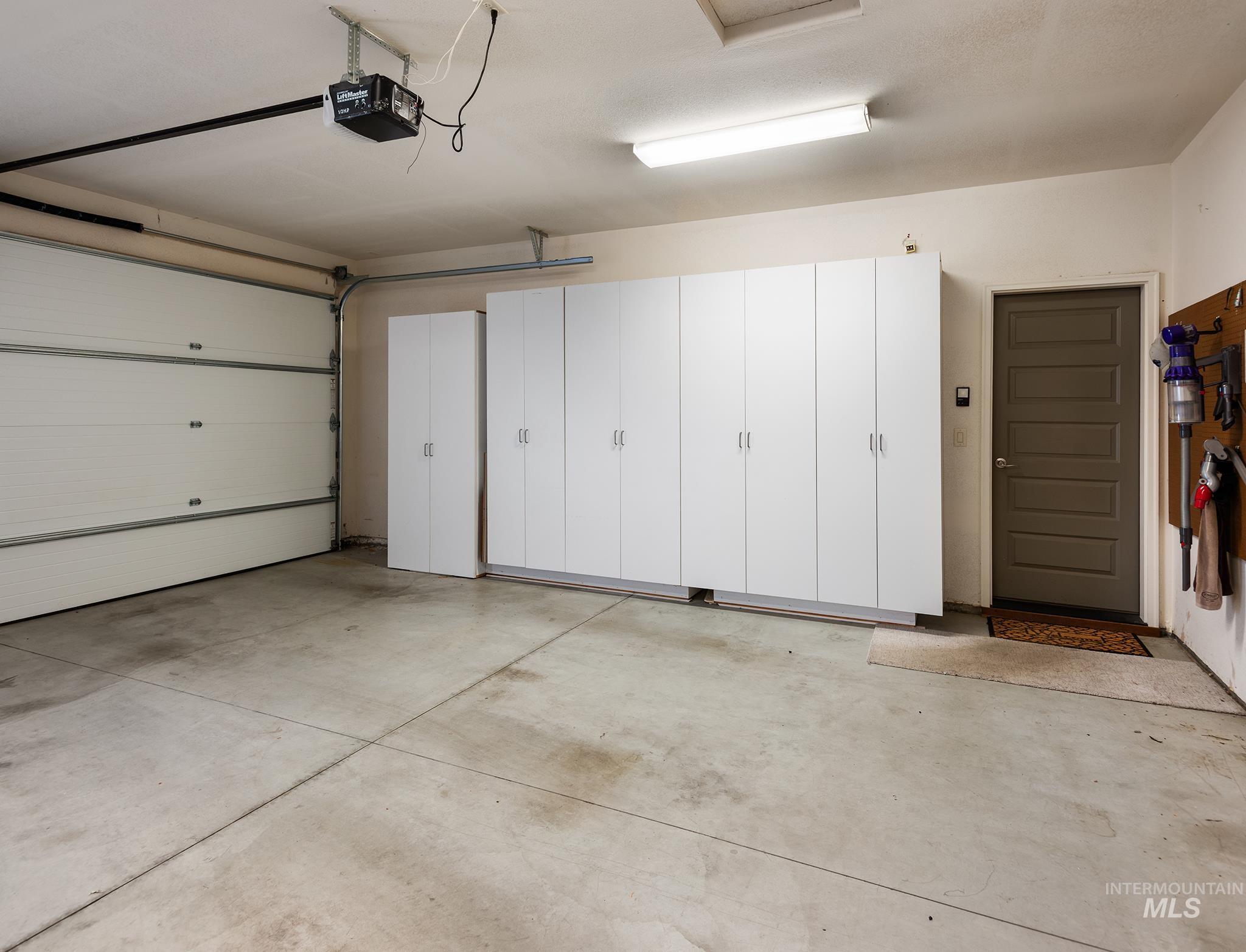 Garage featuring a garage door opener and a central vacuum unit