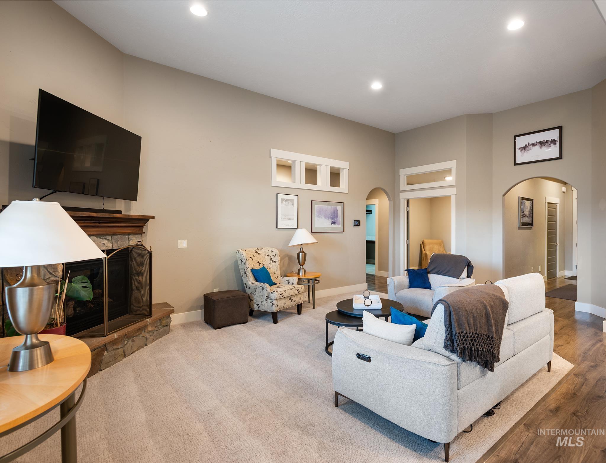 Living room with a fireplace, arched walkways, and recessed lighting