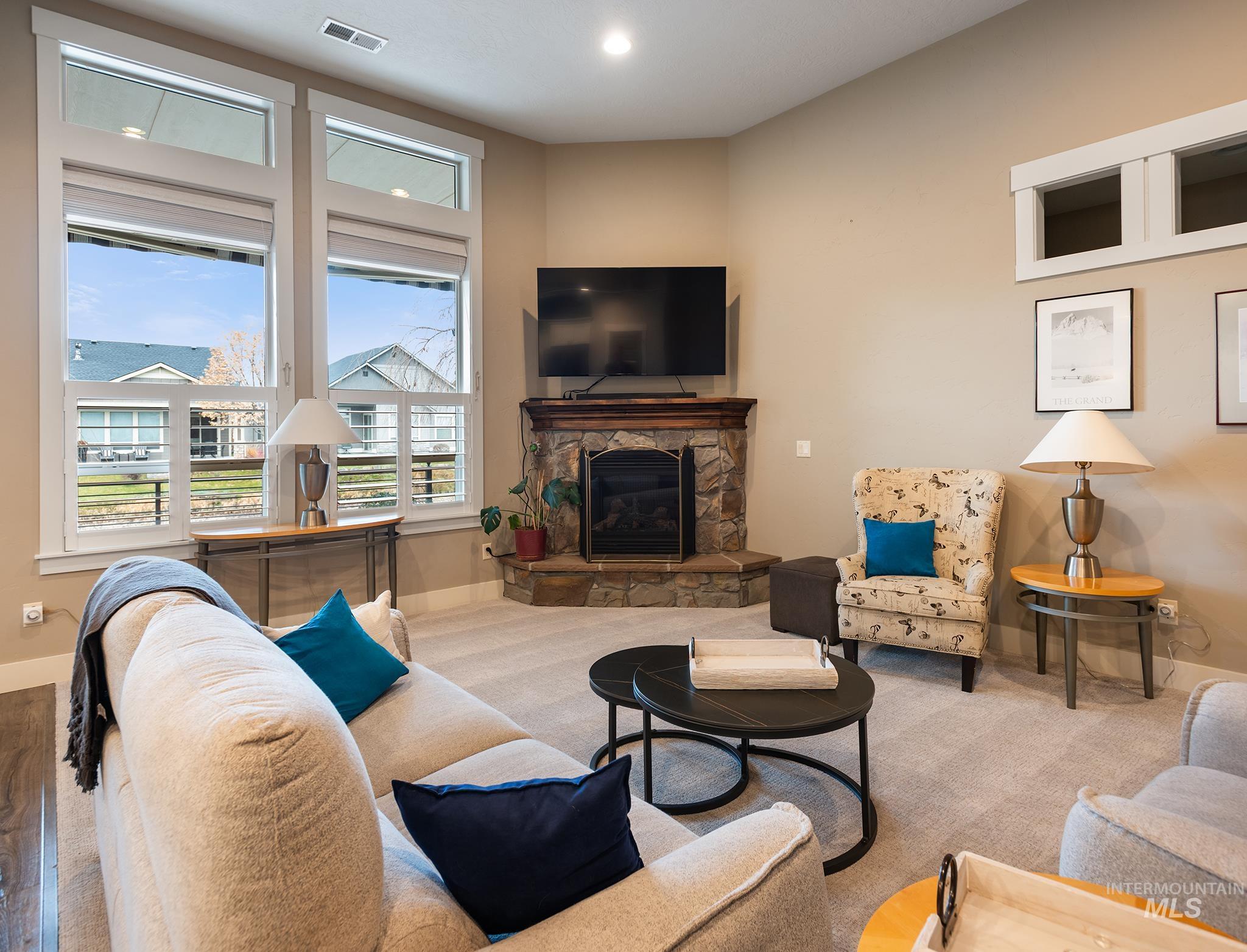 Carpeted living room with a fireplace and recessed lighting