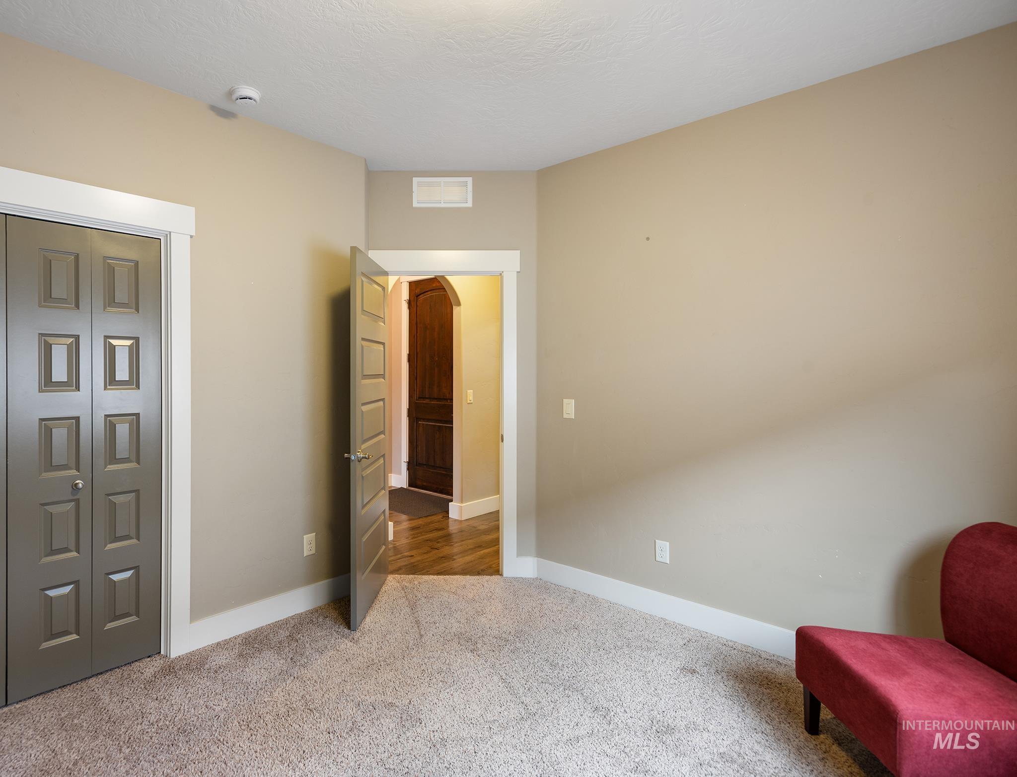 Sitting room featuring carpet, arched walkways, and a textured ceiling