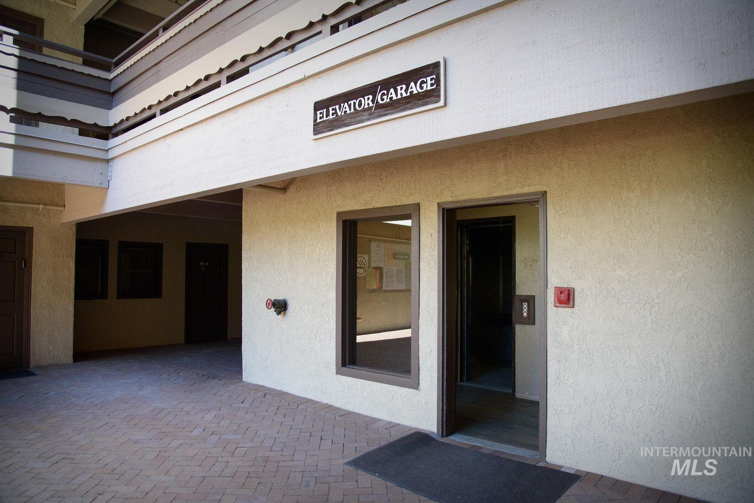 View of exterior entry featuring stucco siding and a patio