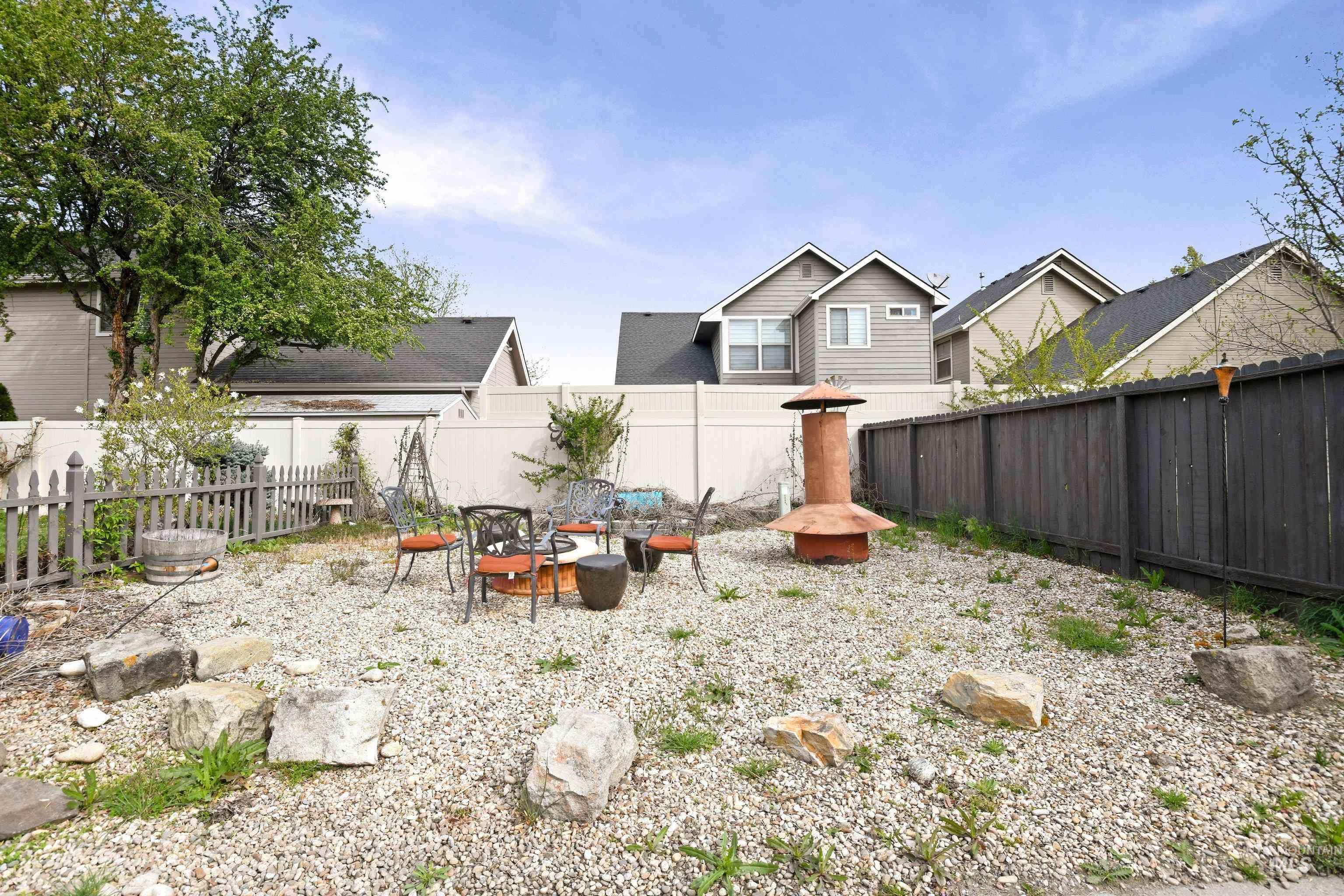 Fenced backyard with a fire pit