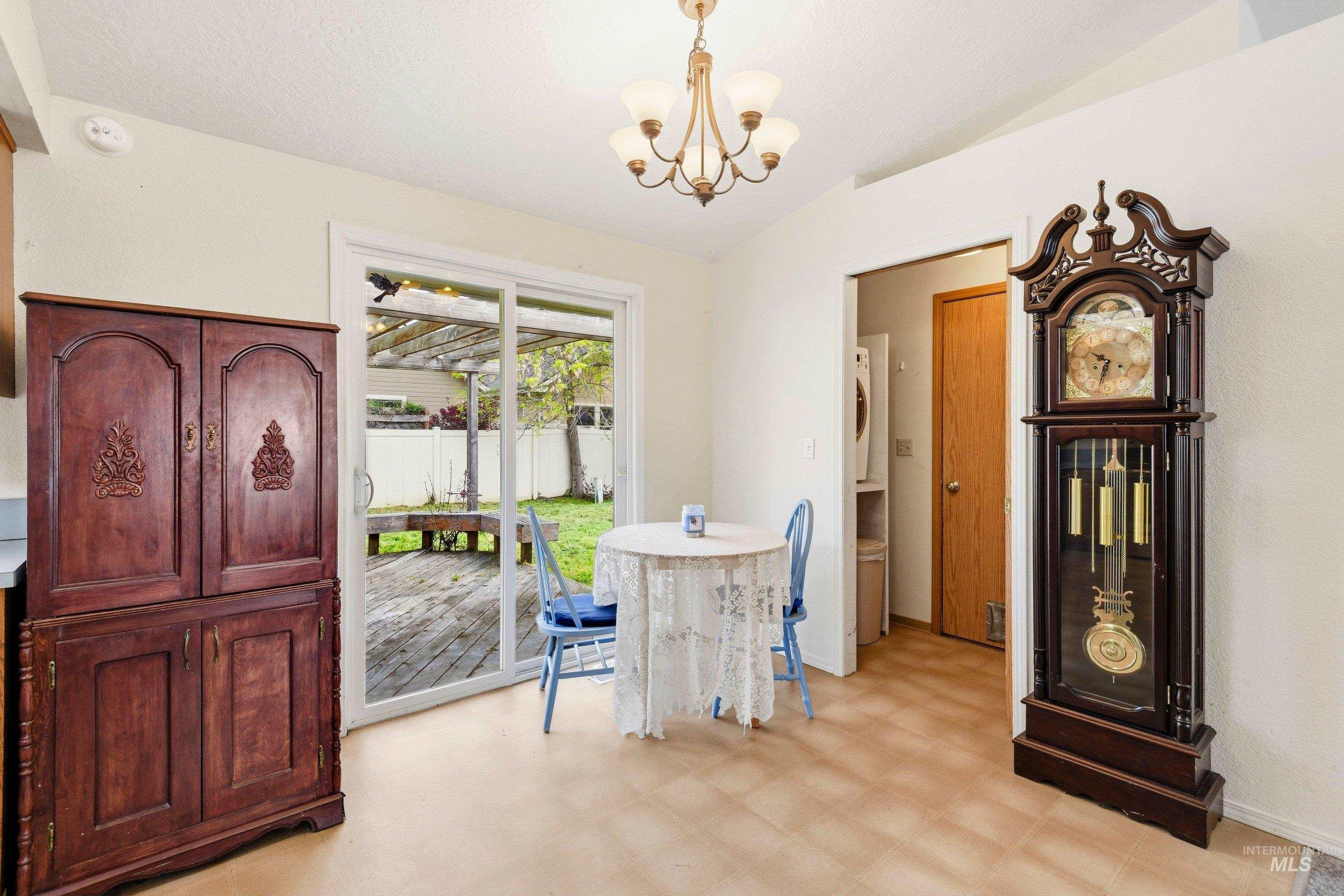 Dining room with light flooring, hanging lights, and lofted ceiling
