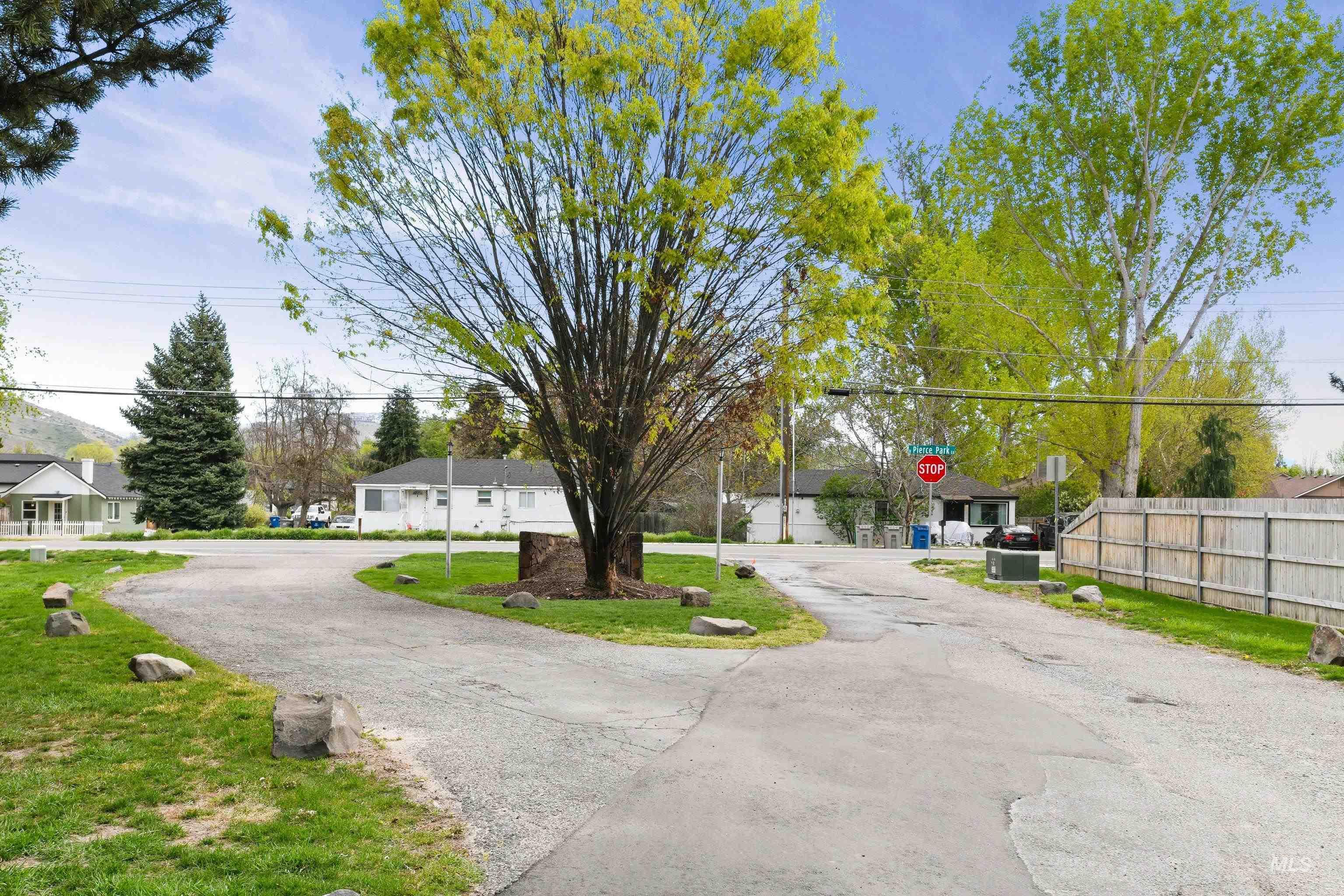 View of asphalt road featuring traffic signs and a residential view