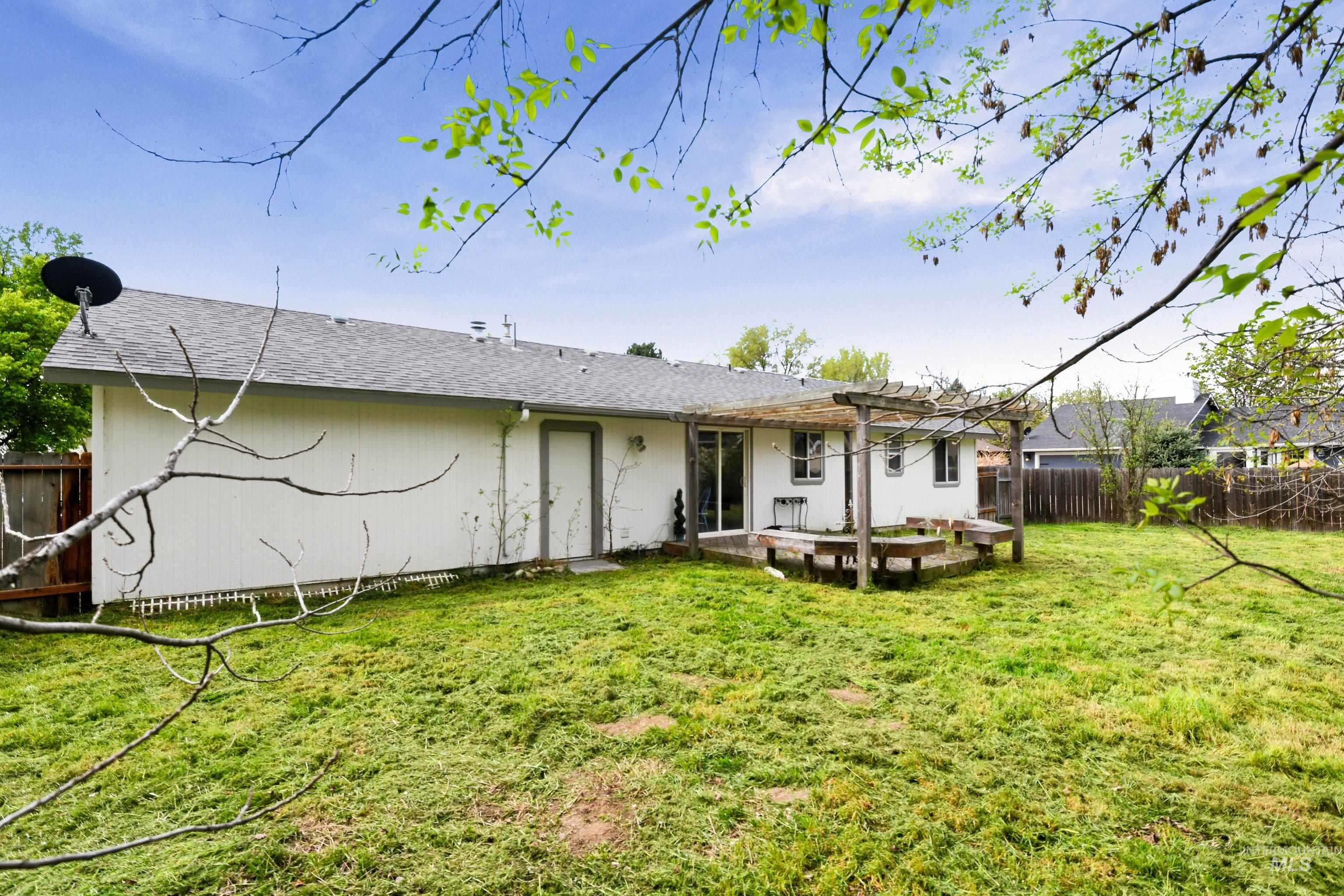 Back of house with a fenced backyard, a patio area, and roof with shingles