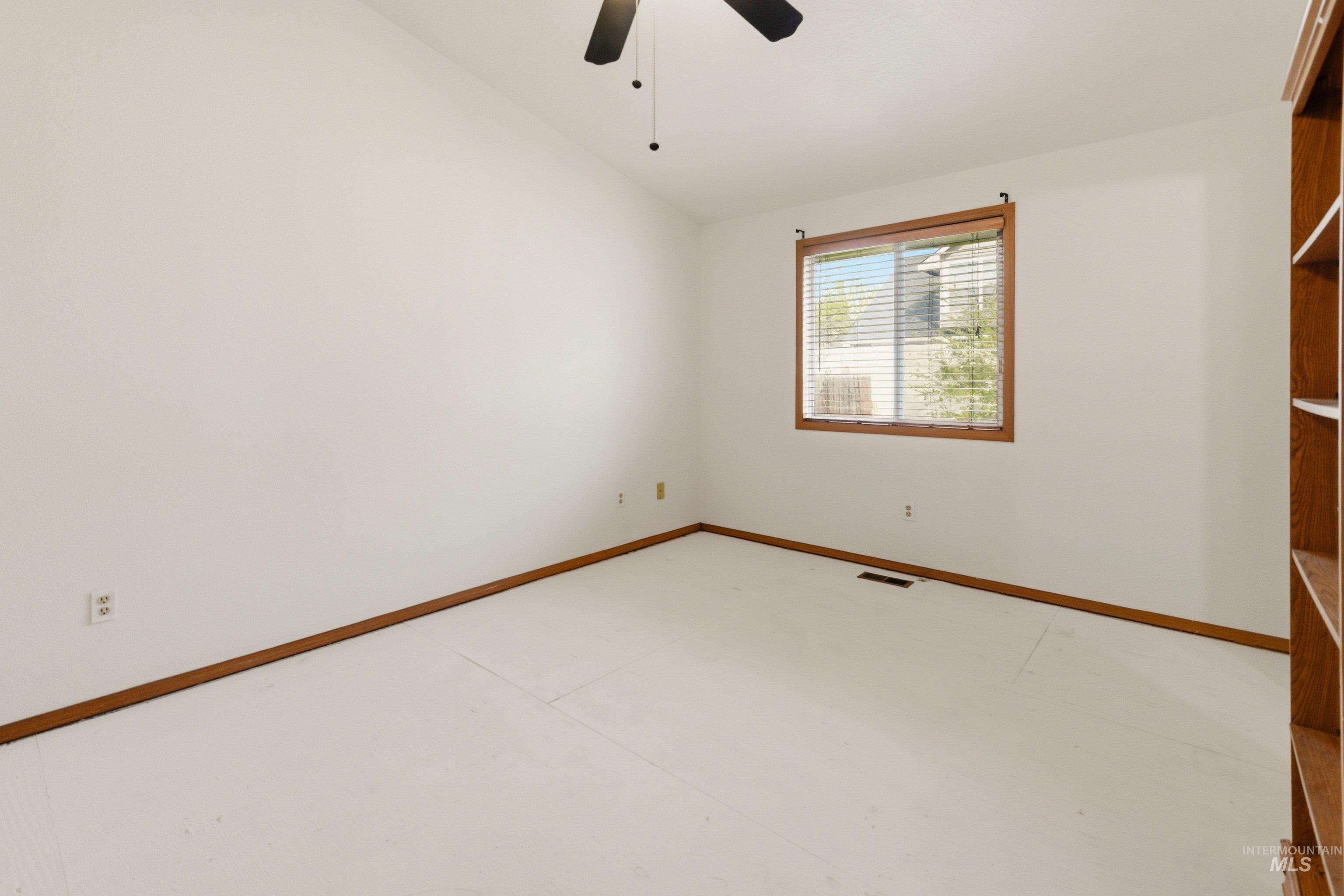 Unfurnished room featuring lofted ceiling and a ceiling fan