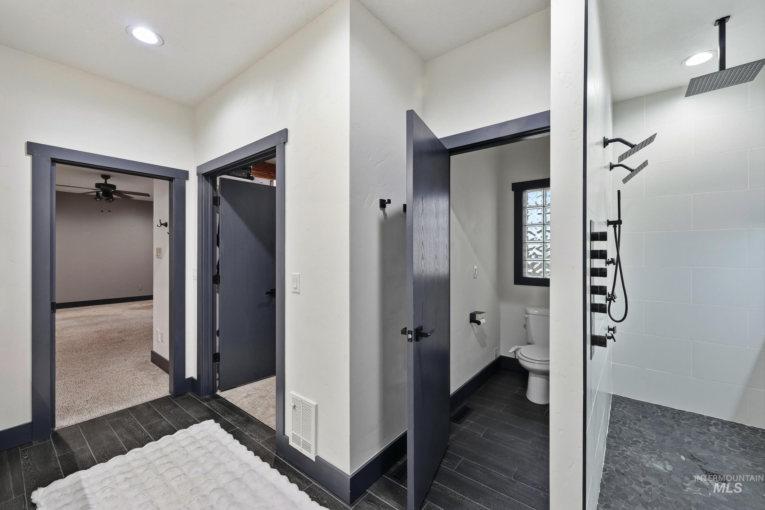 Bathroom with wood finish floors, tiled shower, and recessed lighting