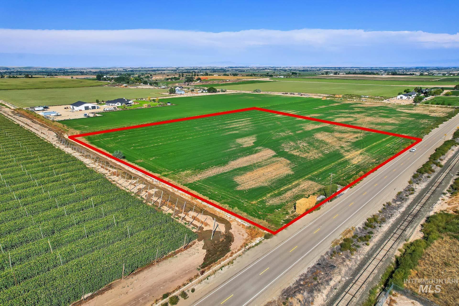 Overview of rural landscape with property parcel outlined and rows of crops