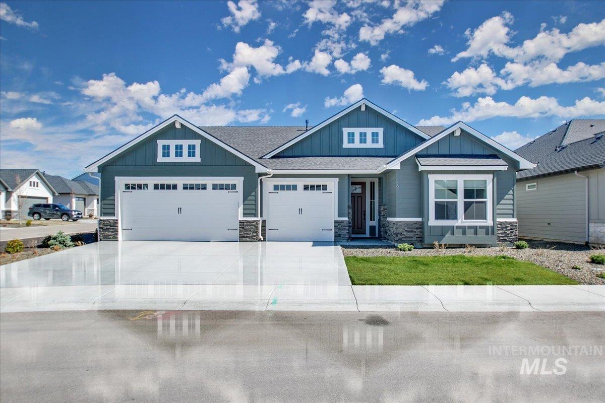 Craftsman-style home with stone siding, board and batten siding, driveway, and an attached garage