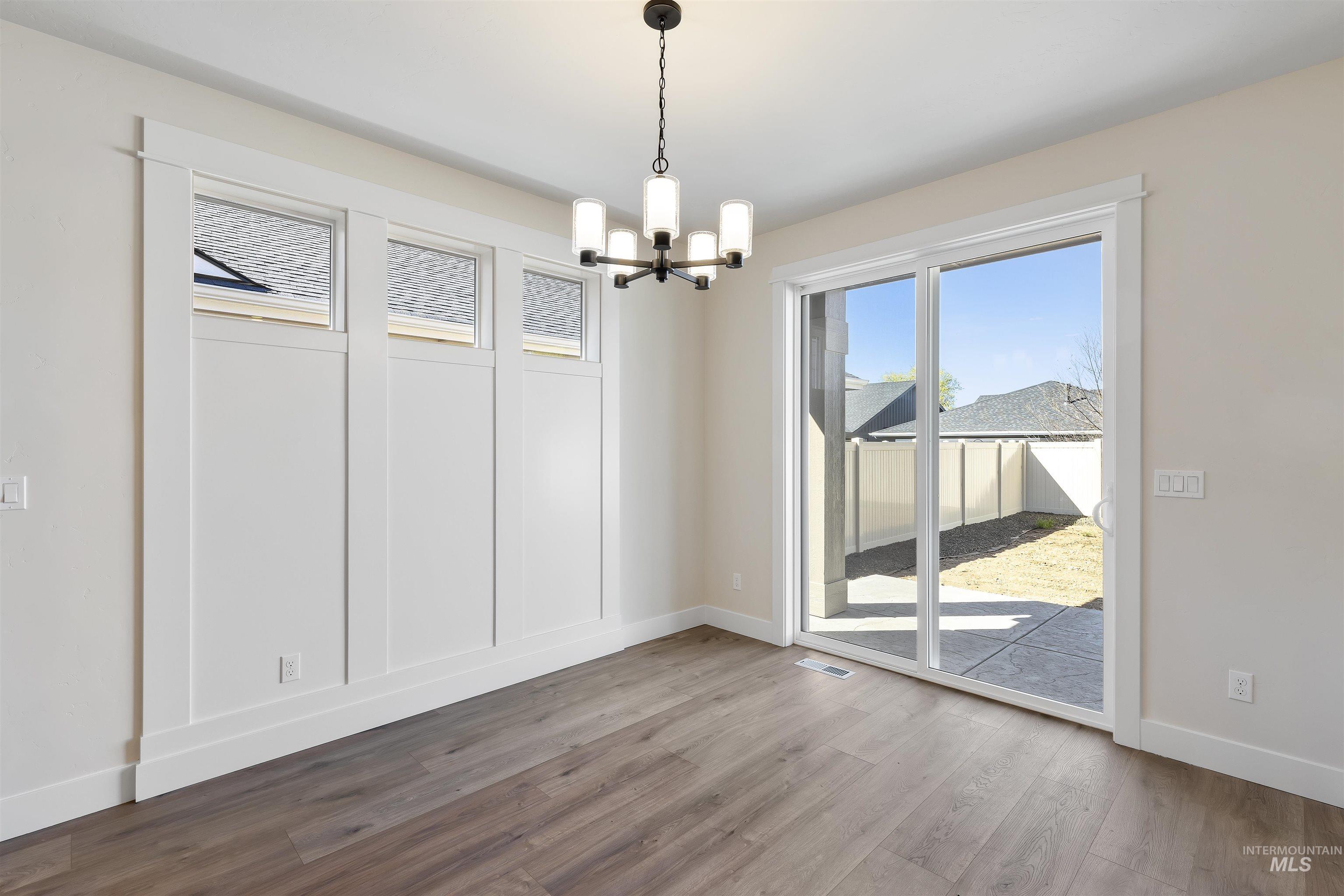 Unfurnished dining area featuring hanging lights and light wood-type flooring