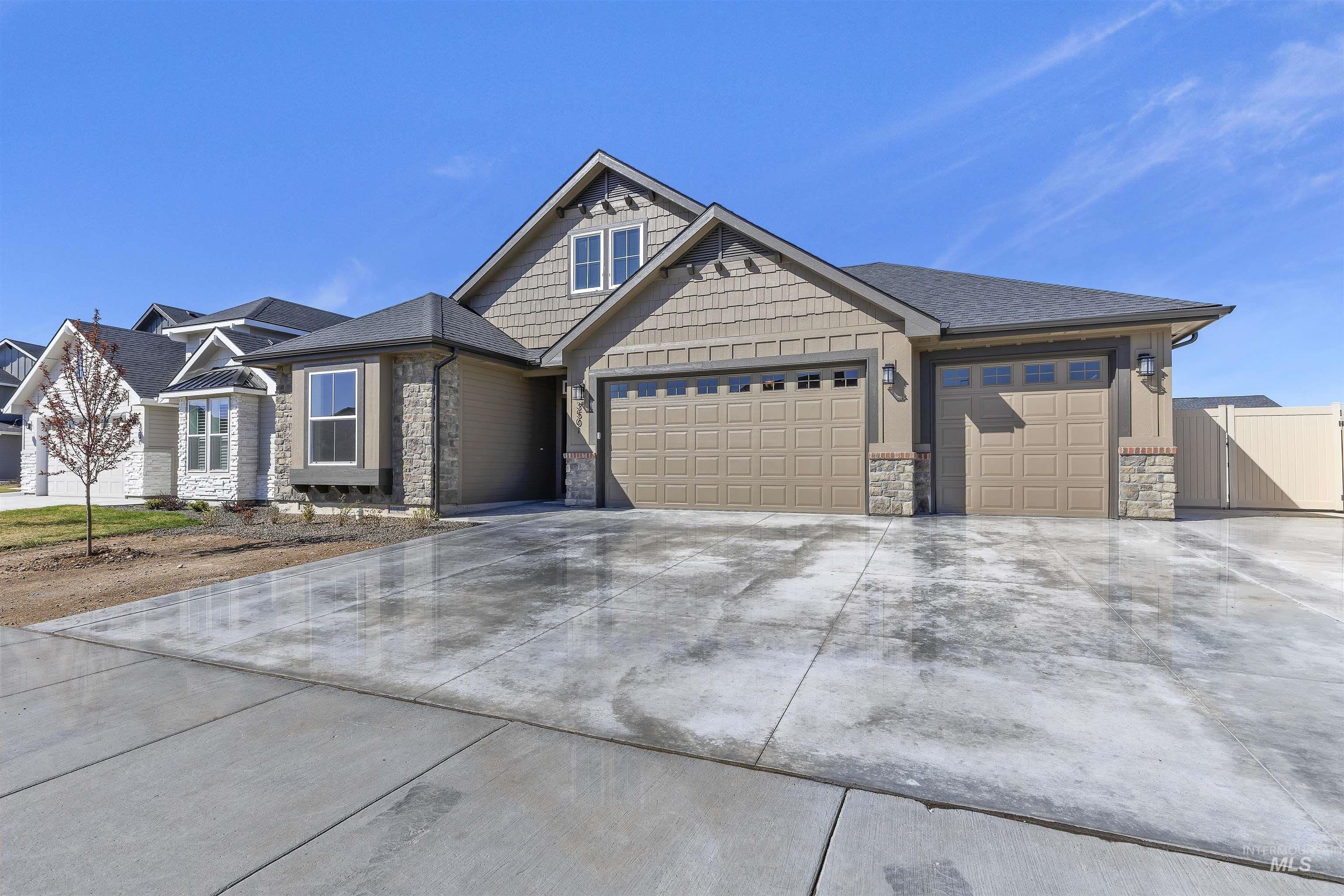 Craftsman house with a garage, stone siding, and concrete driveway