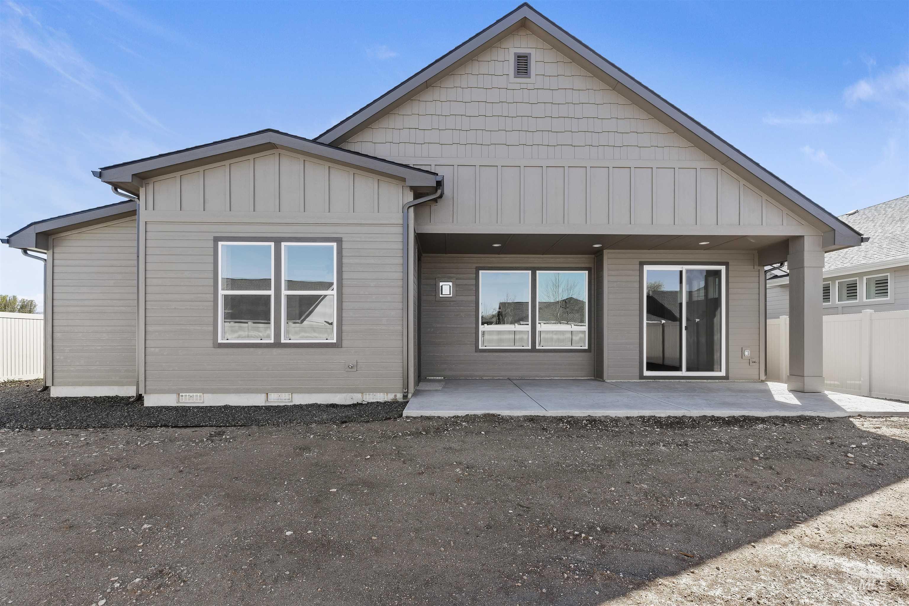 Rear view of property featuring board and batten siding, crawl space, and a patio area