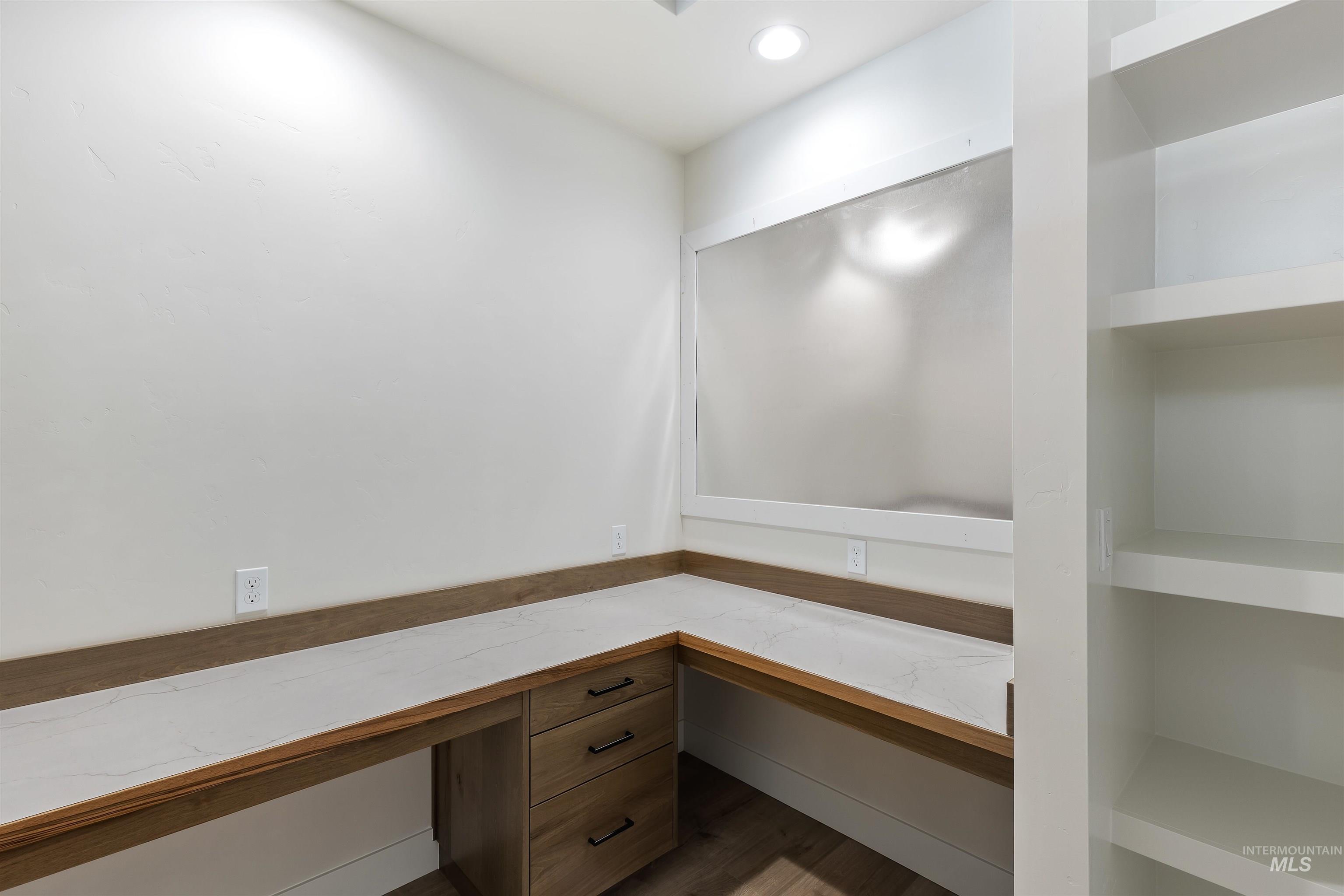 Unfurnished office featuring built in study area, recessed lighting, and wood finished floors