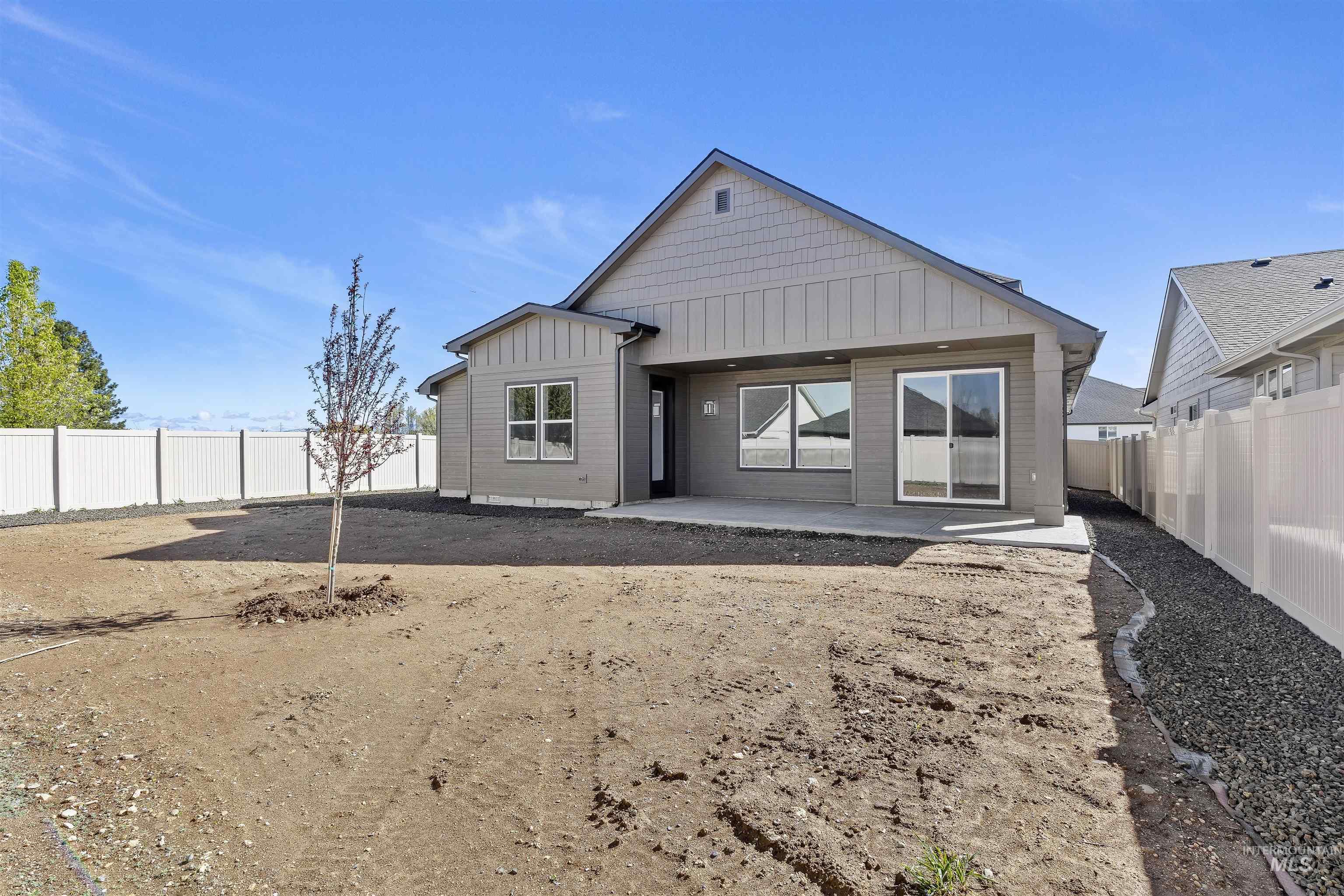 Rear view of property with board and batten siding, a patio, and a fenced backyard