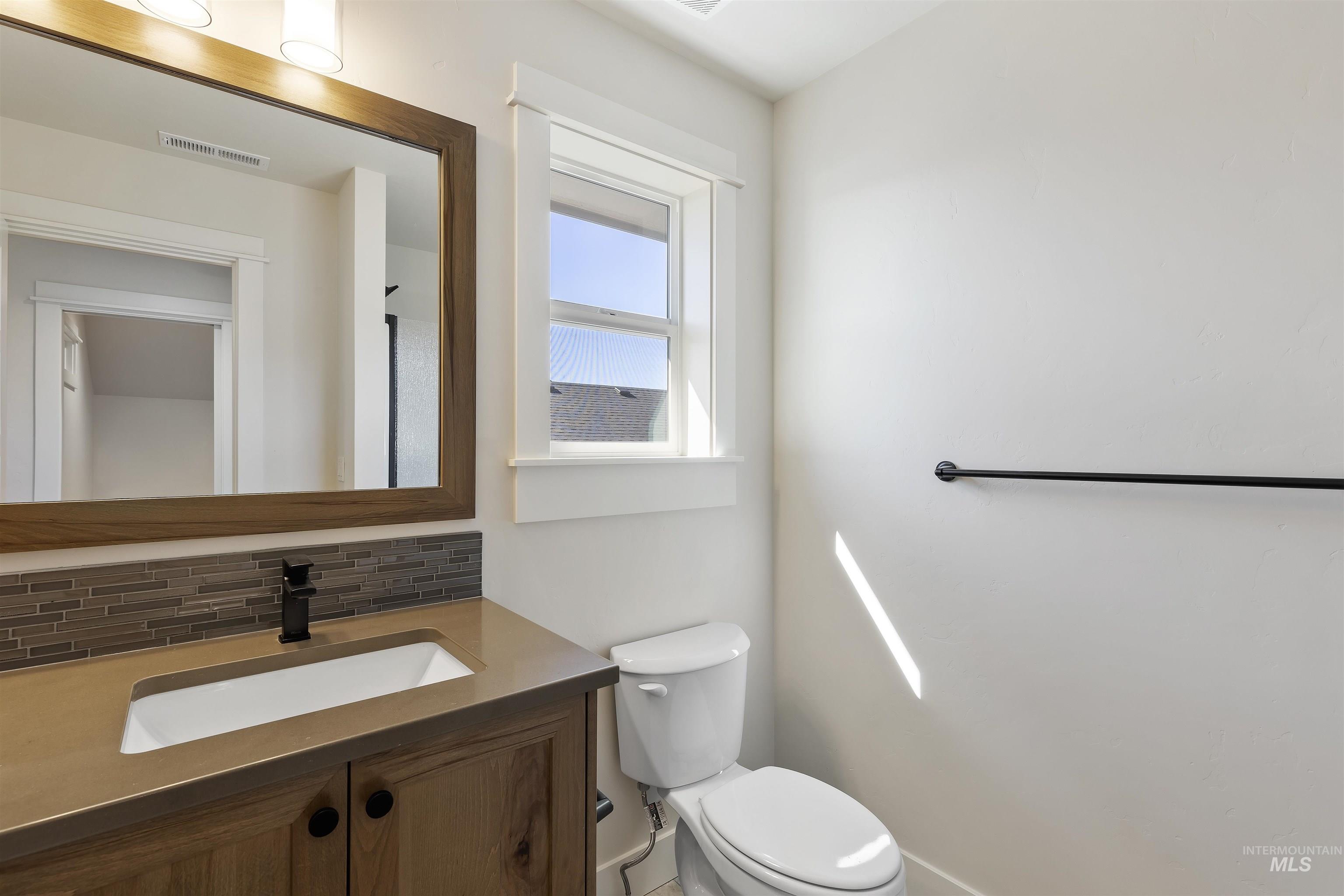 Bathroom with vanity and backsplash