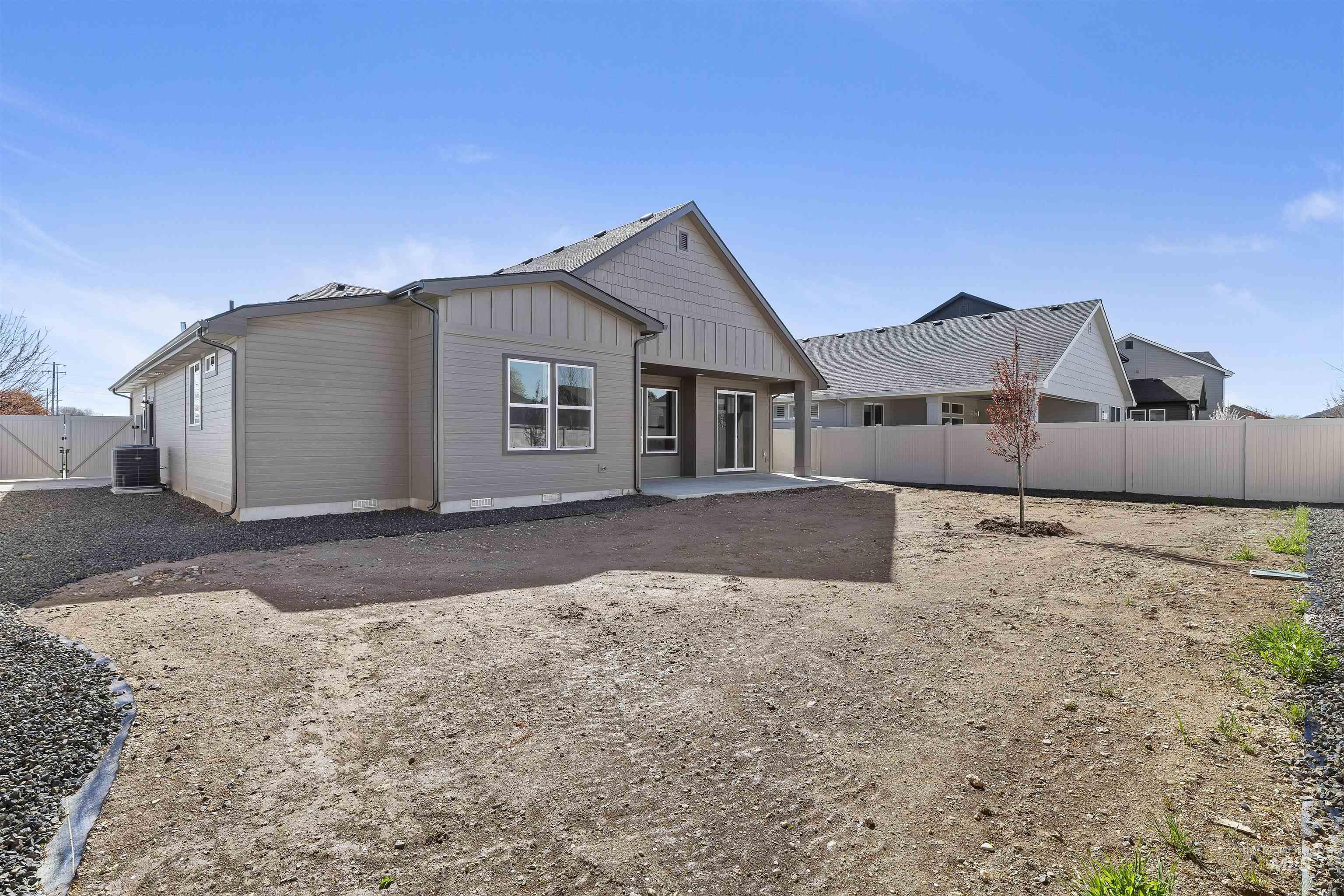 Back of property featuring board and batten siding, a patio, and a fenced backyard